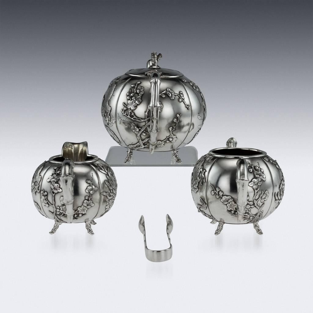 Antique 20th century Chinese export solid silver four-piece tea set, comprising of teapot, sugar bowl, milk jug and sugar tongs, each spherical body applied with dragons and flowers in relief, cast spout modelled as a bamboo branch, handles also