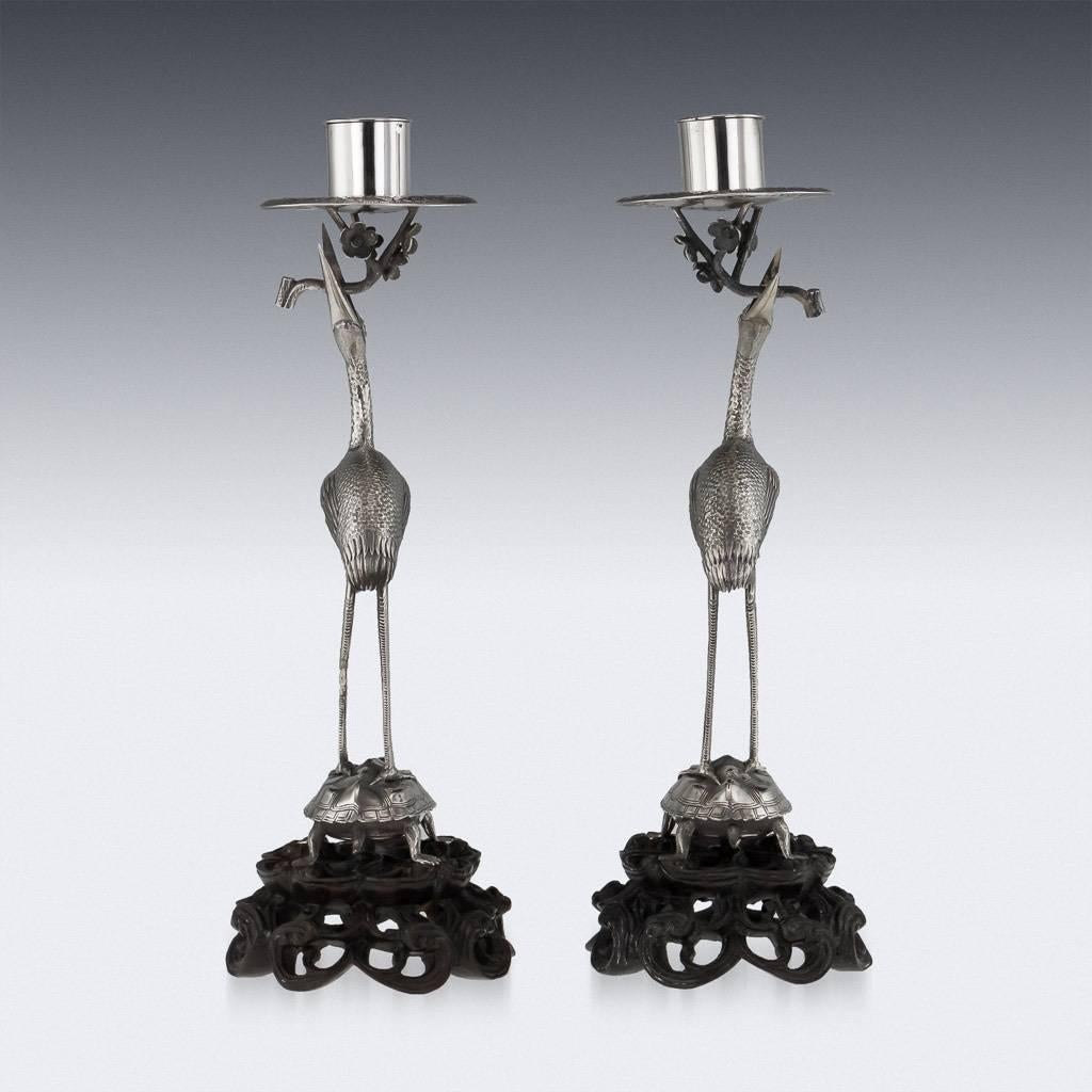 Antique 20th century rare Chinese solid silver decorative pair of candlesticks, realistically modelled as pair of cranes standing on a tortoise, mounted on a hand-carved, pierced wood base. Cranes with turned heads grasping a cherry blossom branch