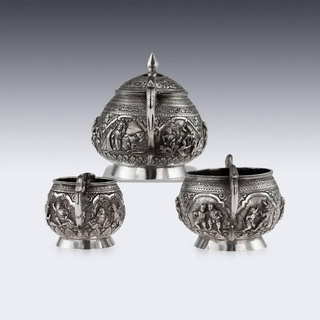 Antique early-20th century Burmese, Myanmar solid silver three-piece tea set, comprising of teapot, sugar bowl and cream jug, each piece is highly-decorative, chased and repoussed with various scenes from Burmese mythology on finely tooled ground.