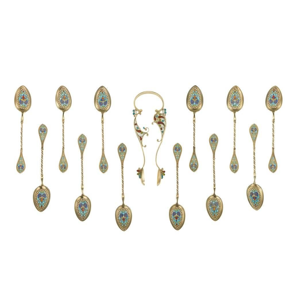 Antique late 19th century Norwegian solid silver gilt and enamel decorative spoons and sugar tongs, beautifully decorated with colorful plique-a-jour enamel, filling a filigree floral decoration. Comes in its original leather bound retail