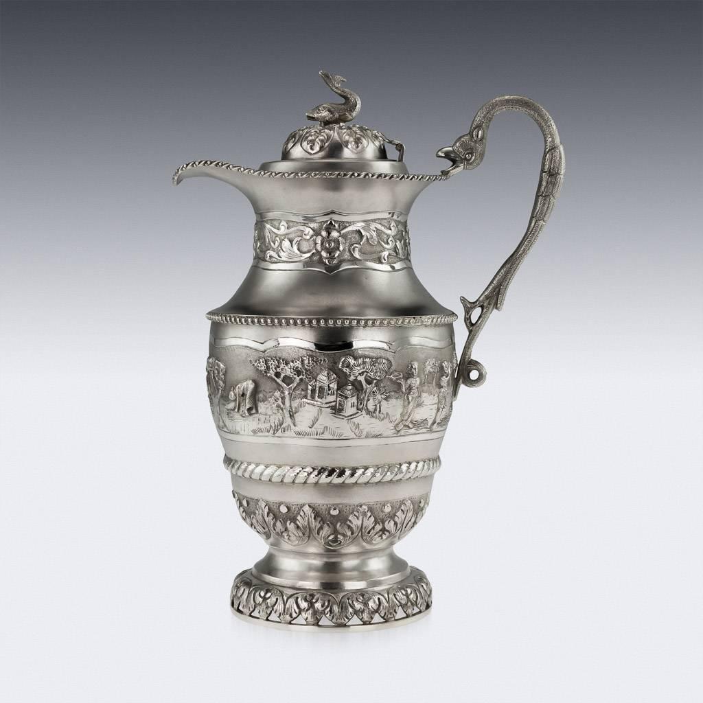 Antique 20th century Indian Colonial solid silver ewer and six goblets, jug of baluster body resting on a pieced, domed circular foot, cast bird shaped scroll handle and hinged domed lid mounted with a cast fish, the body and the neck is repoussé