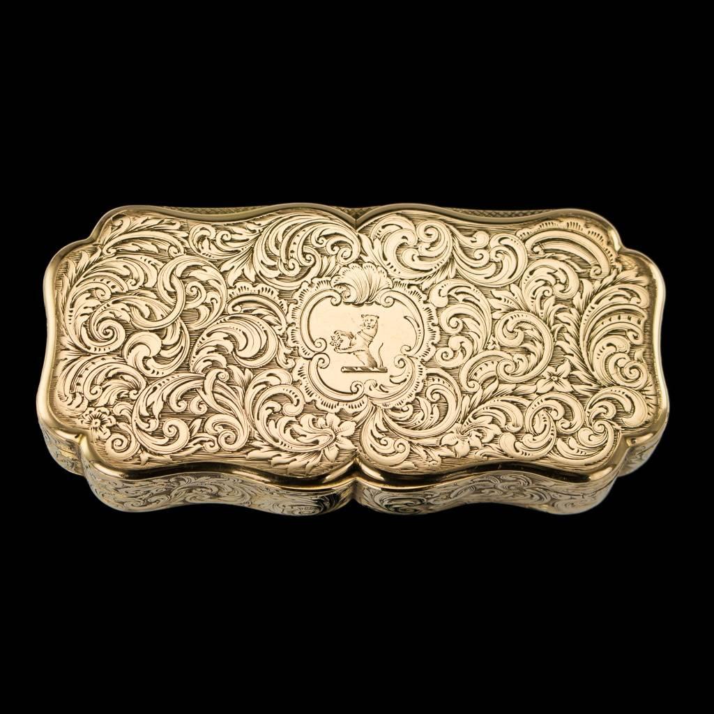 Antique 19th century Victorian 18-karat solid gold snuff box, cartooche shaped, cover , base and body profusely engraved with scrolling foliage, the base with central vignette depicting a ship at sea, the cover cartouche engraved with a crest of a