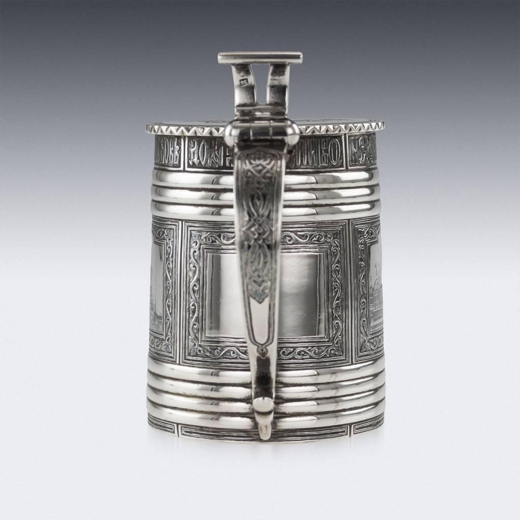 Antique 19th century Imperial Russian solid silver and niello presentation lidded tankard, parcel gilt, of traditional form, C-shaped handle terminating with a large thumb-piece, decorated with a niello enamel, depicting famous Moscow landmarks, the
