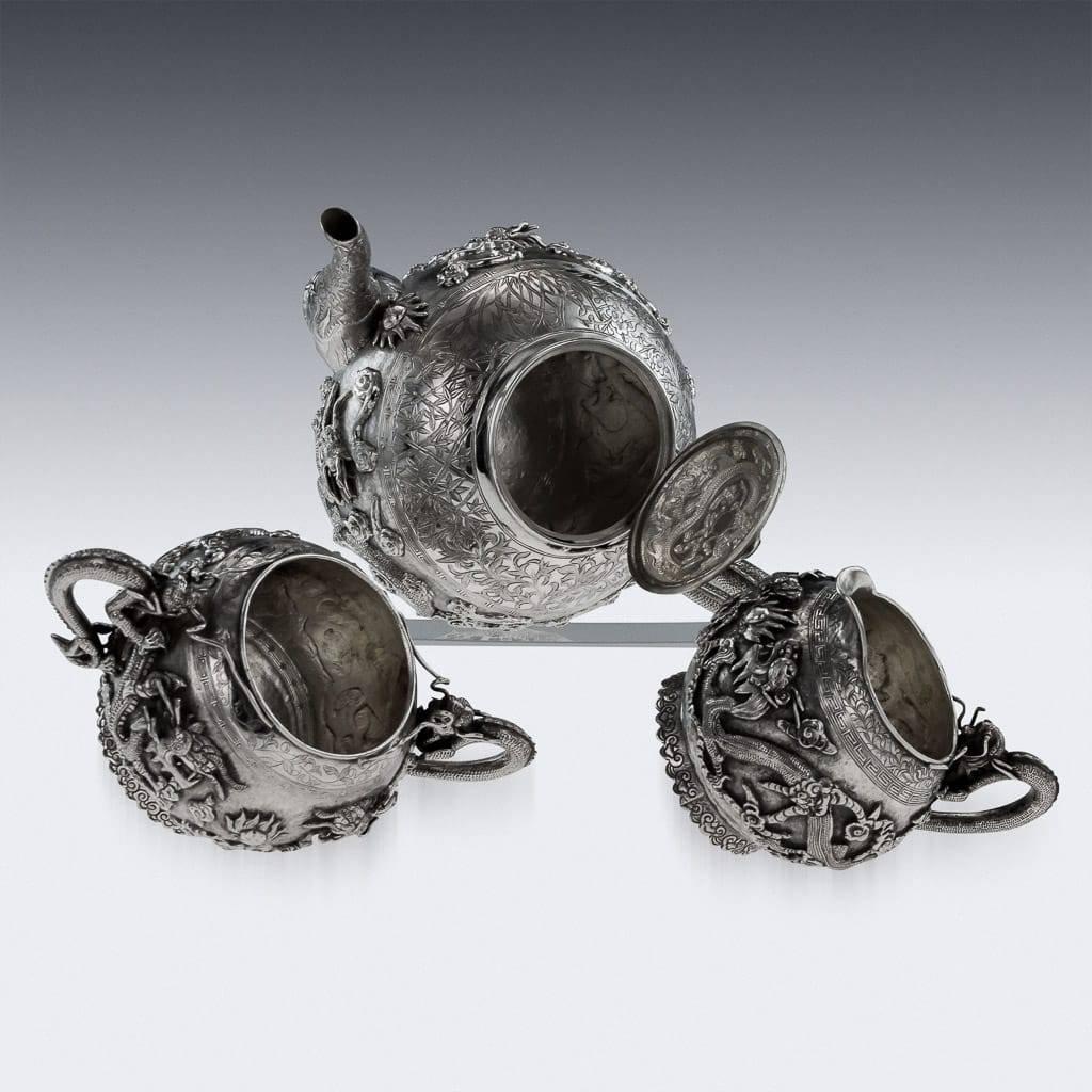 Service à thé antique du 19ème siècle en argent massif:: comprenant une théière:: un sucrier et un pot à lait:: chaque corps sphérique est magnifiquement appliqué avec des dragons chassant la perle flamboyante de la sagesse:: surface martelée::