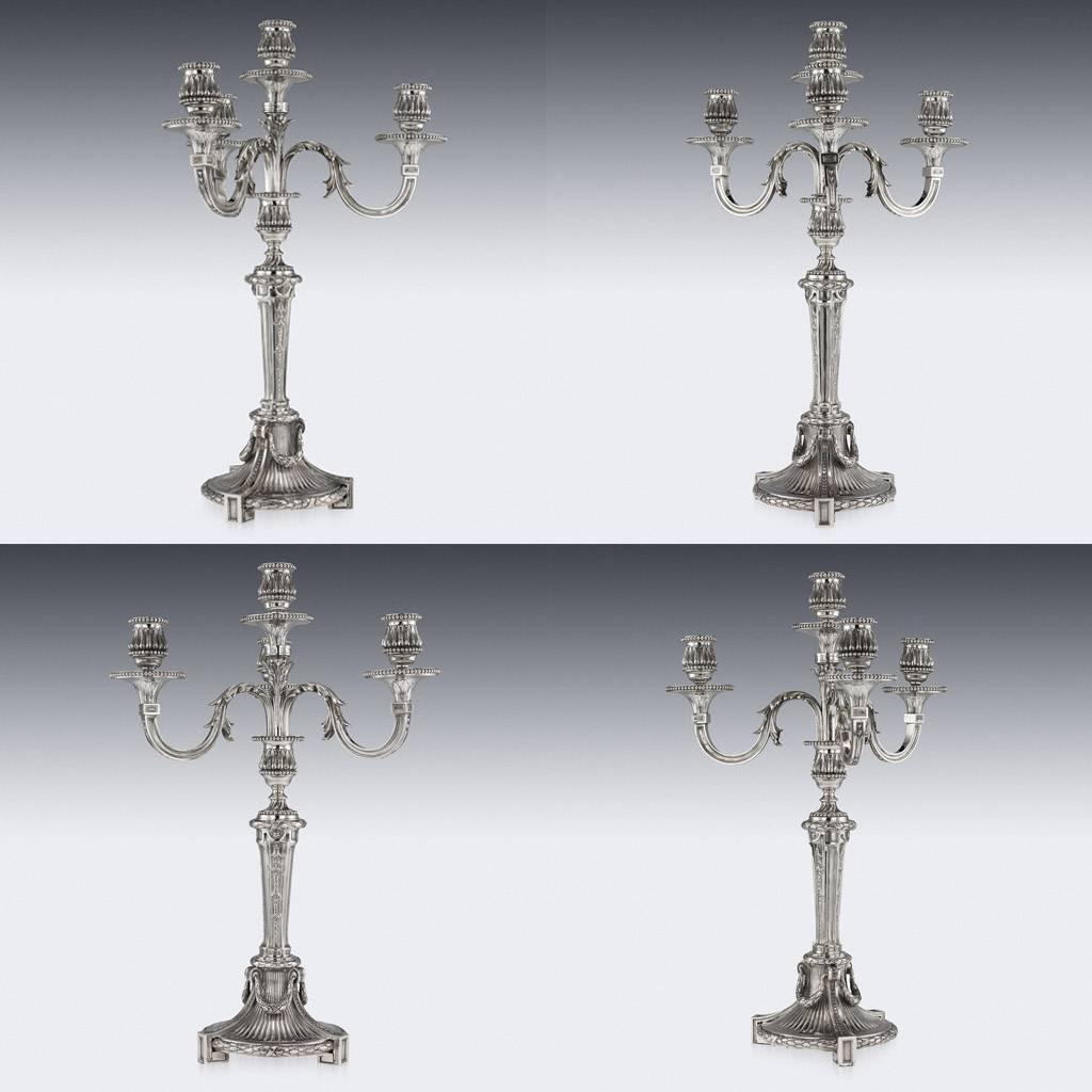 Antique late-19th century French pair of magnificent five-light candelabra, large and exceptionally heavy, made in the Louis XVI style, each on cast circular bases, standing on three square feet, column decorated with foliage and ribbon-tied husk
