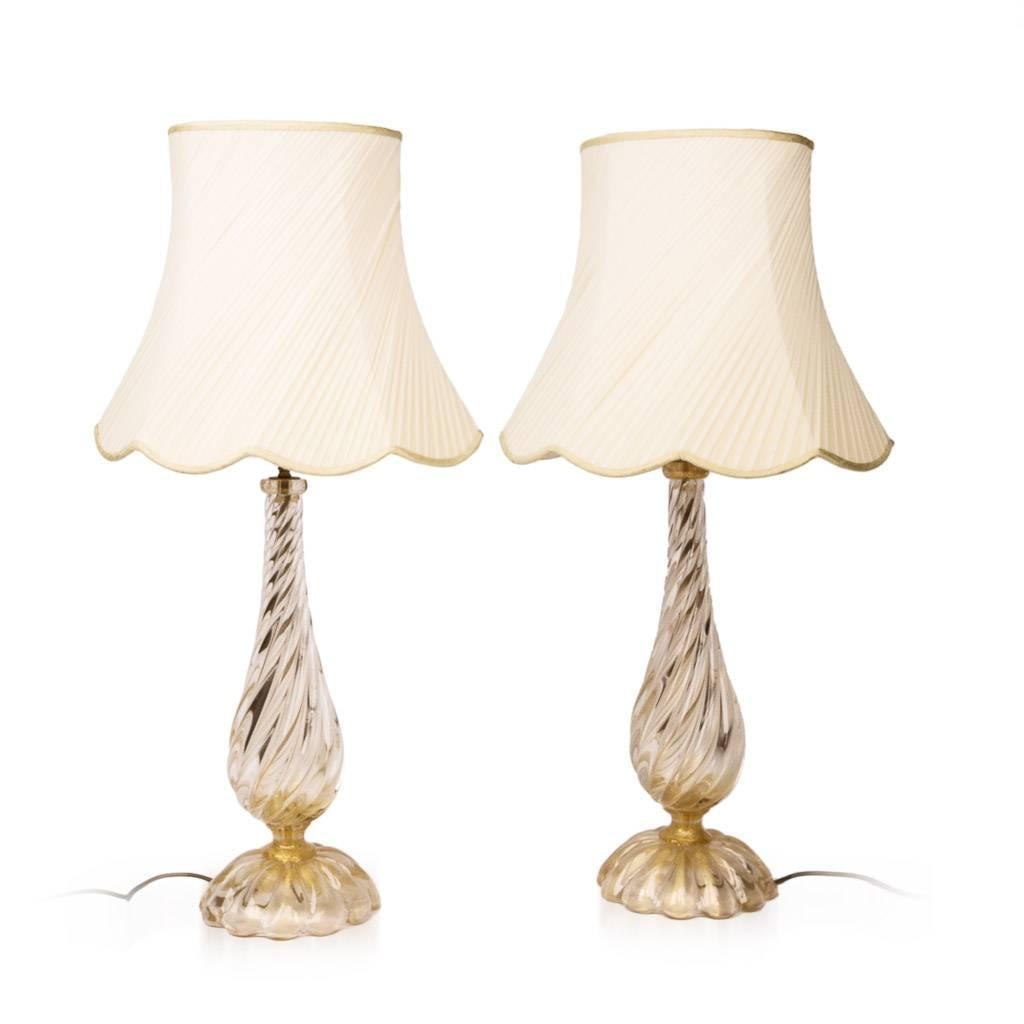 Genuine mid-20th Century pair of Italian Archimede Seguso Murano glass lamps, each of baluster form with a domed base and a swirl-fluted design, with gold accents.

The base bearing the etched signature for Archimede Seguso, and the original