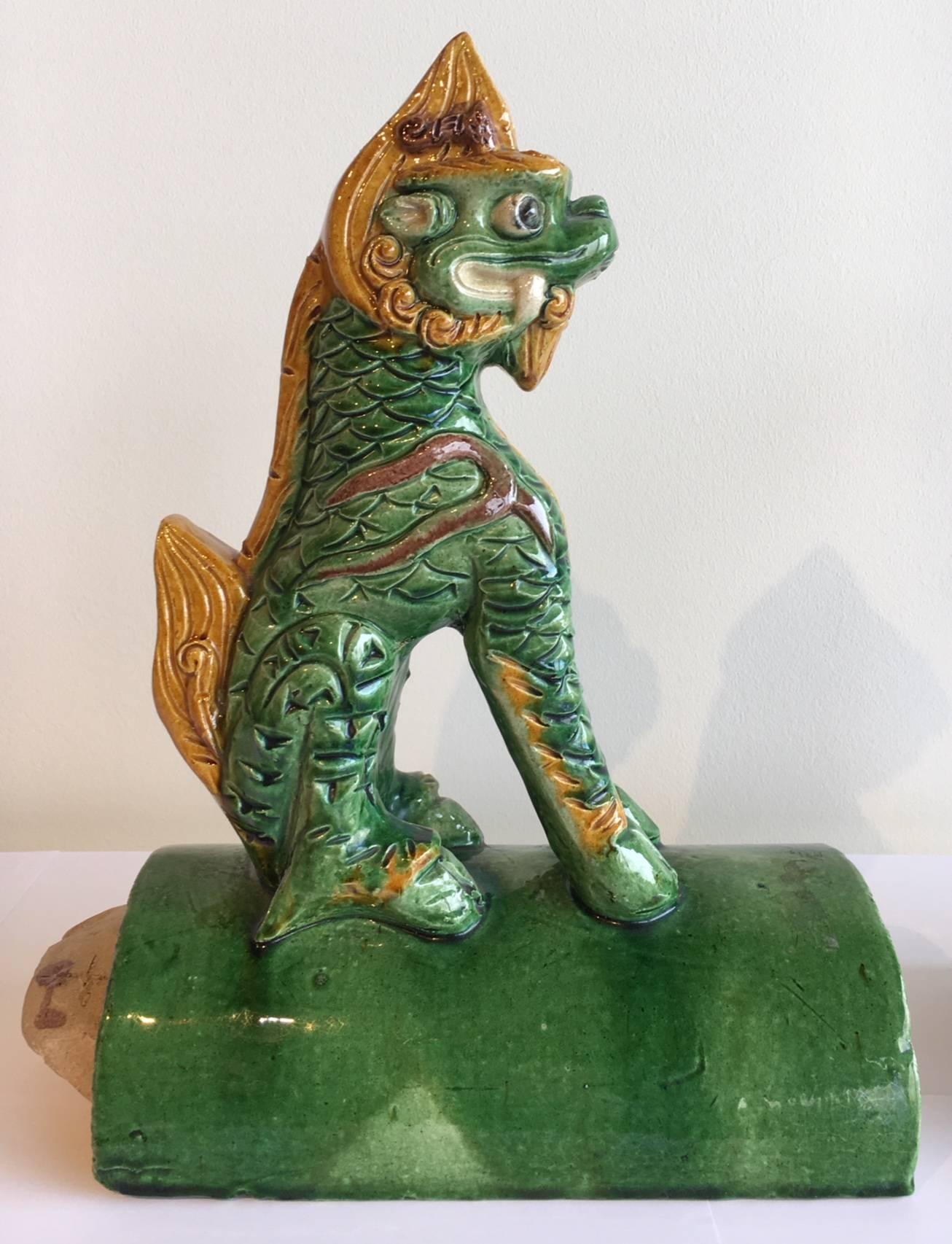 Pair of antique Chinese “foo dogs” roof tiles. 
Rare pair of foo dog tiles in stunning green and yellow gold from the late 19th century.

Size: H: 13.75