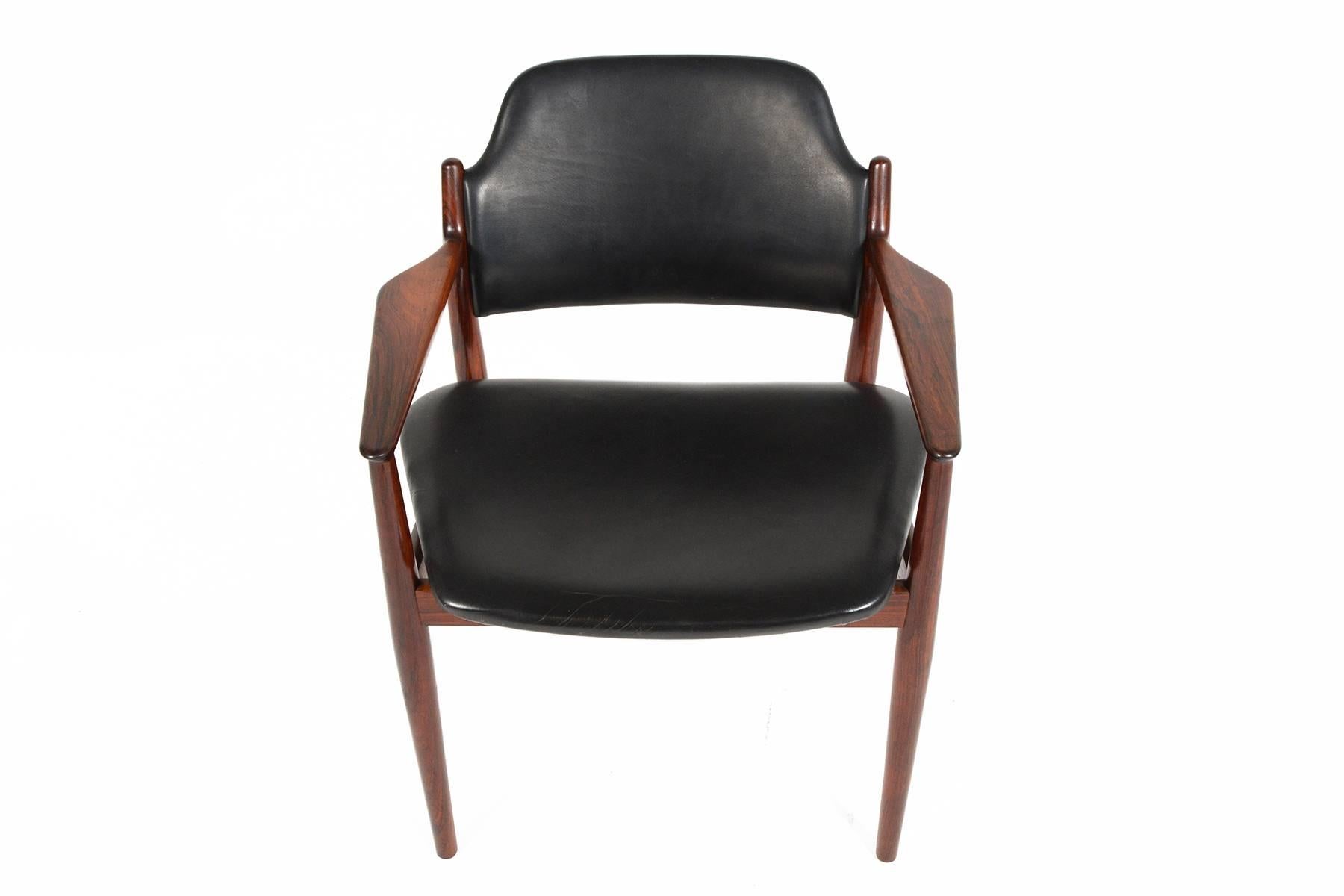 This gorgeous armchair was designed by Arne Vodder for Sibast Møbler in 1961. This model 62A is crafted in beautiful solid Brazilian rosewood and wears its original black leather upholstery. In excellent original condition with typical wear for its