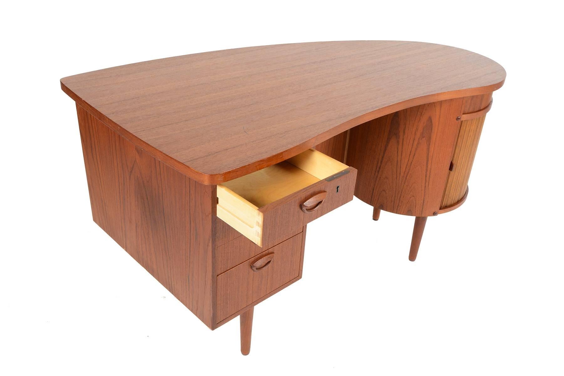 This rare Danish modern Model 54 executive desk was designed by Kai Kristiansen for Feldballes Mobelfabrik in the 1960s. Crafted in old growth teak, this desk features four drawers with Kristiansen's distinctive circular pulls, bookshelf back, and a