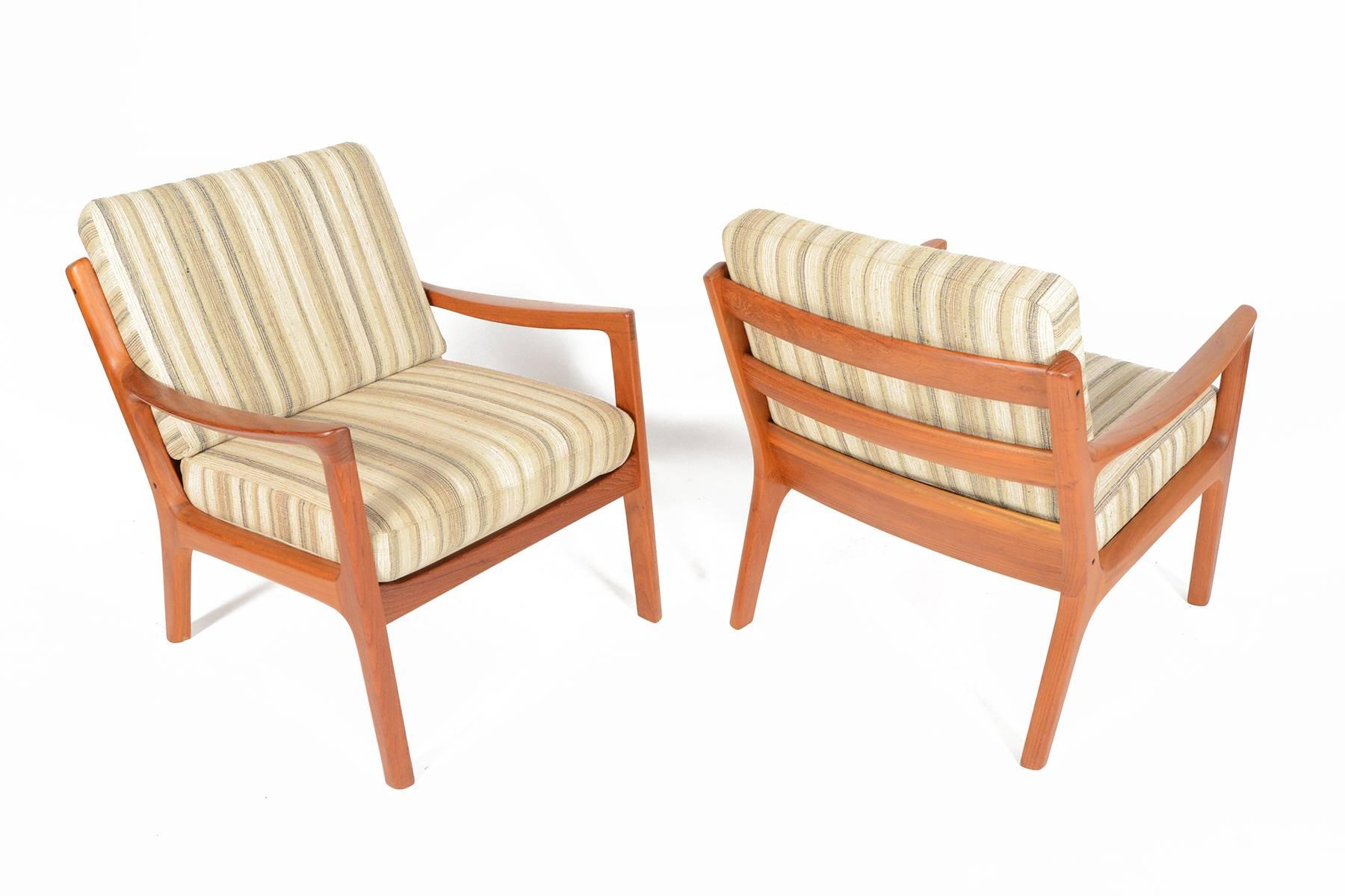 This pair of Senator Model 166 teak lounge chairs was designed by Ole Wanscher for Cado in the 1960s. Crafted in solid teak with understated elegant lines, this pair is extremely comfortable and will be a great addition to any modern collection.