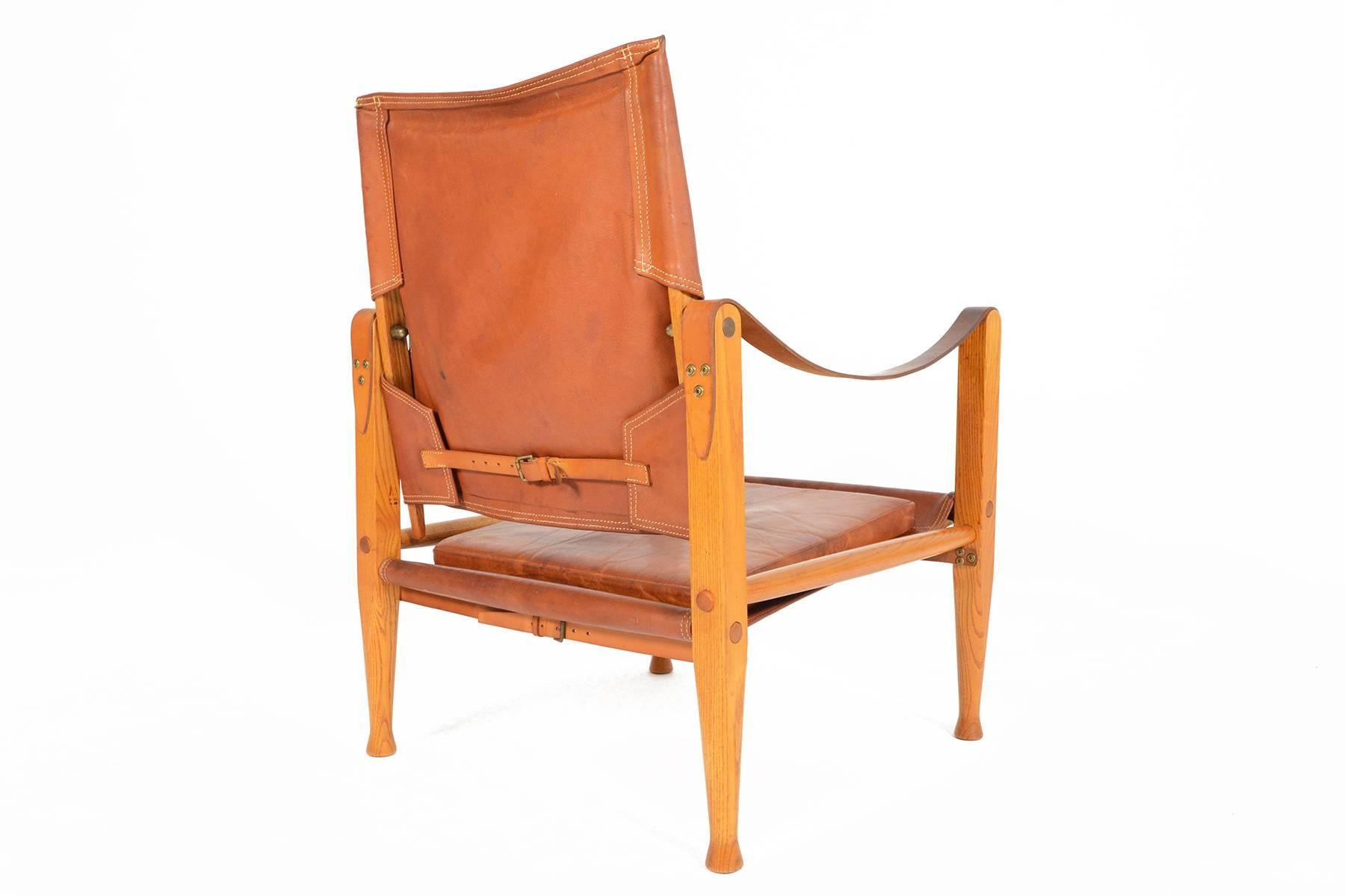 This gorgeous Danish modern safari chair was designed by Kaare Klint in the 1933. The exposed oak frame uses the support of doweled rods, slung leather and brass buckled straps. The backrest swivels for added comfort. The beautiful original burnt