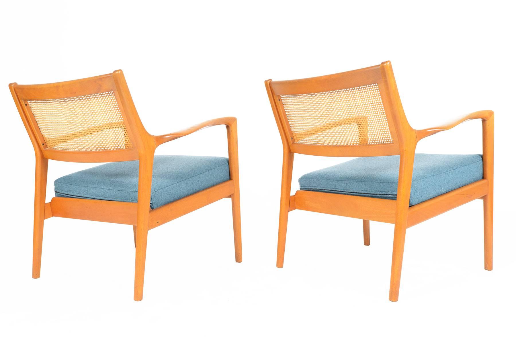 This pair of model F139 Karl Erik Ekselius for JOC Möbler oak and cane lounge chairs are an exceptional find. Sculpted arms and legs offer a beautiful contoured form. With their original cane backrests, these chairs can floated in any room for an
