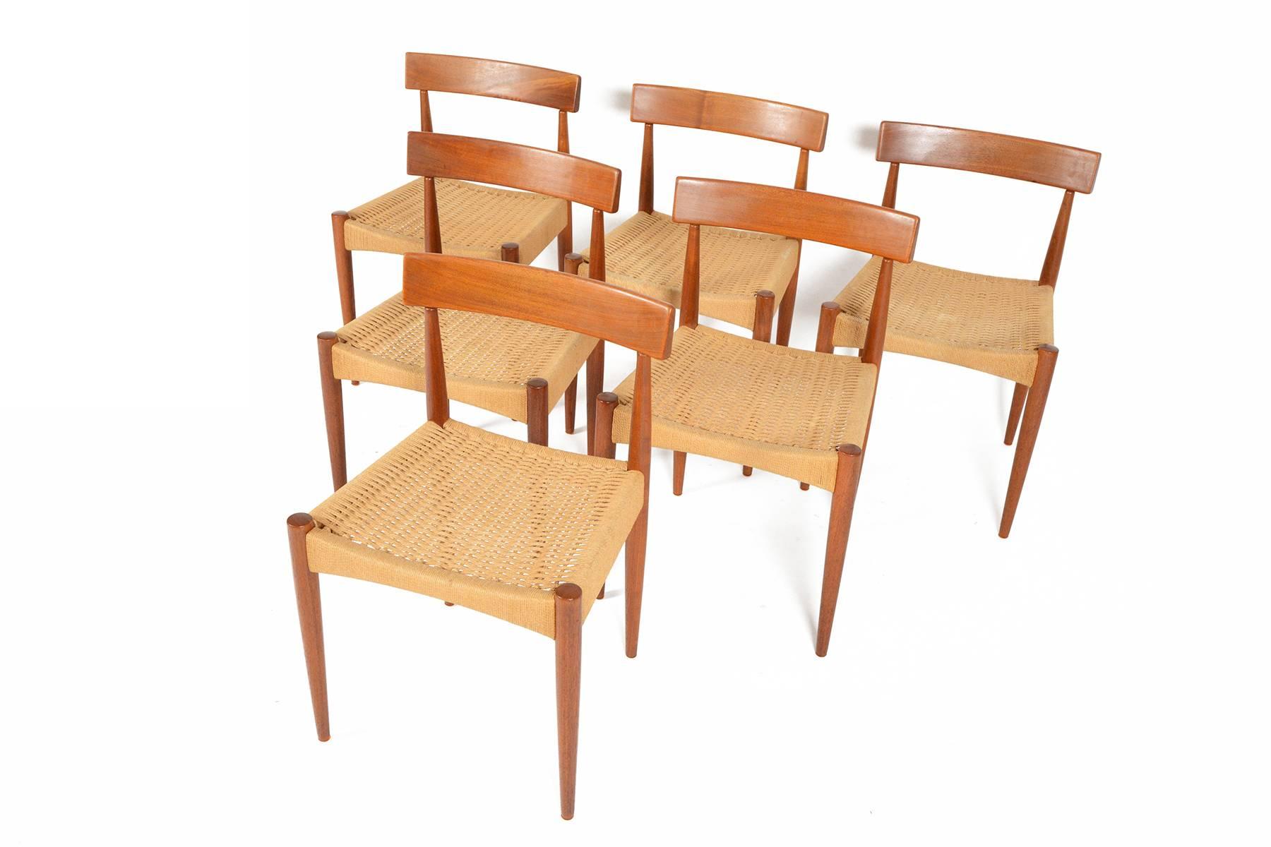 Designed by Arne Hovmand Olsen for Mogens, Kold, this gorgeous set of six Danish modern dining chairs are a quintessential addition for any Scandinavian inspired dining room. Each chair features a curved teak back rest and solid teak spindle legs.