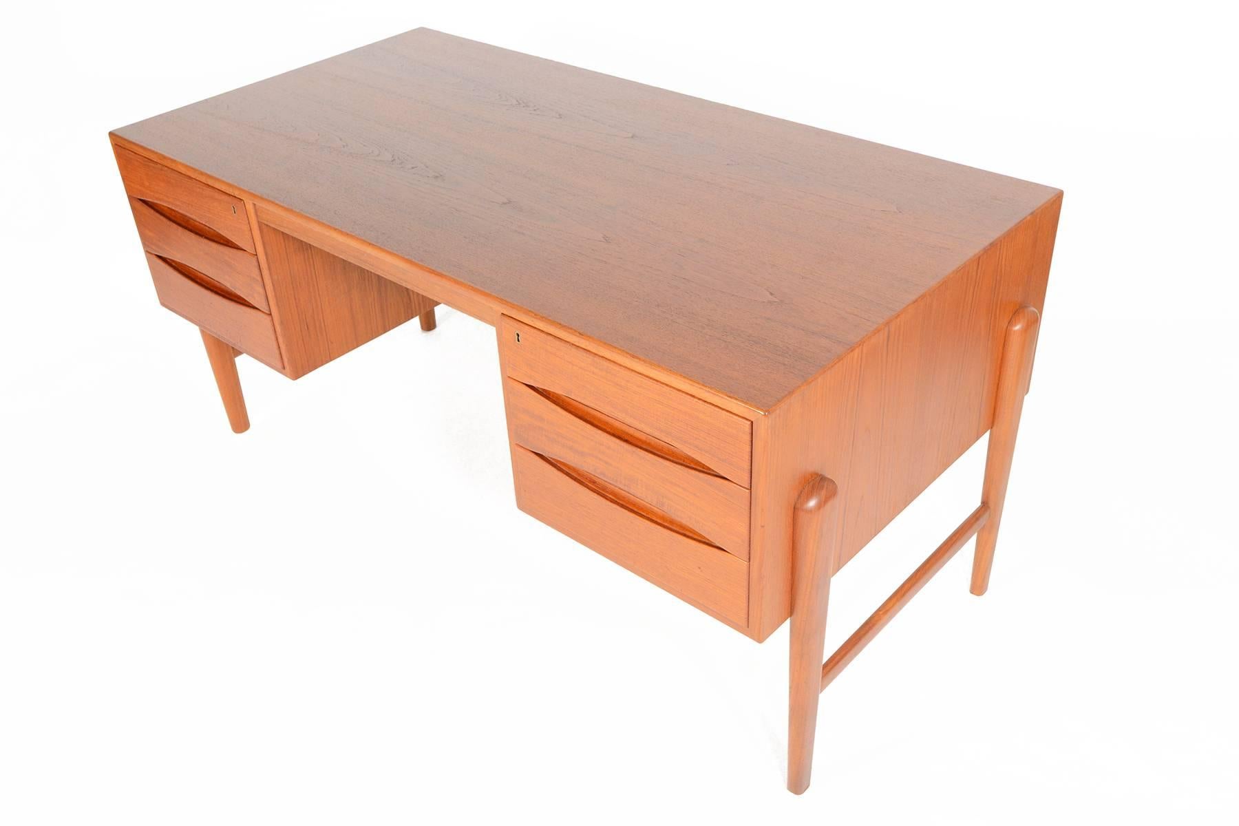 This Danish modern floating top desk in teak is the perfect piece for any modern office! The kneehole is nestled between two banks of three drawers. Deep drawers extend the depth of the desk and offers a finished back allowing this piece to be