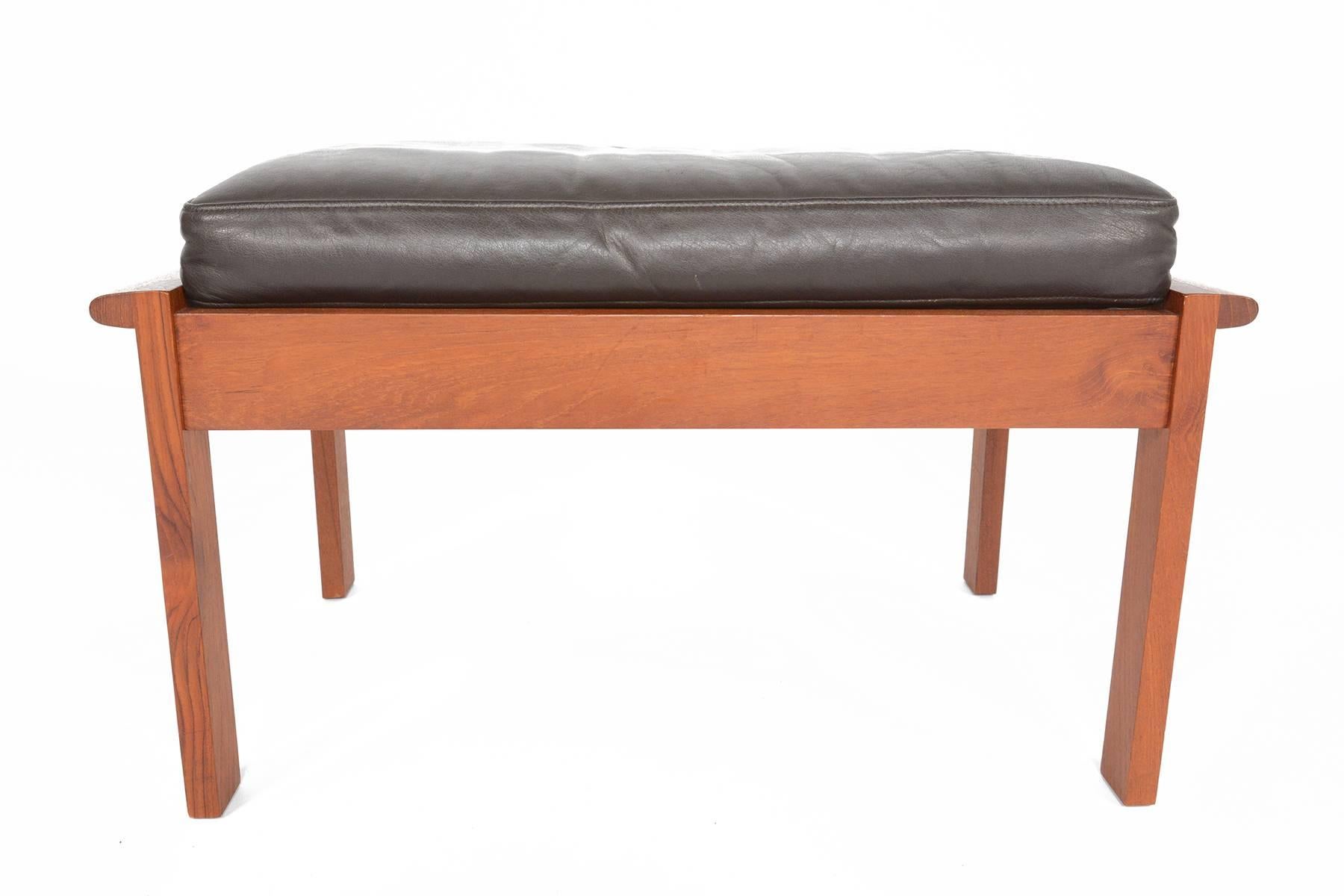 This beautifully sculpted teak ottoman known as the ' Capella' model was designed by Illum Wikkelsø for Niels Eilersen in 1959. Expertly crafted from solid teak, this ottoman features elegant box joints and flared sides. The frame holds its original