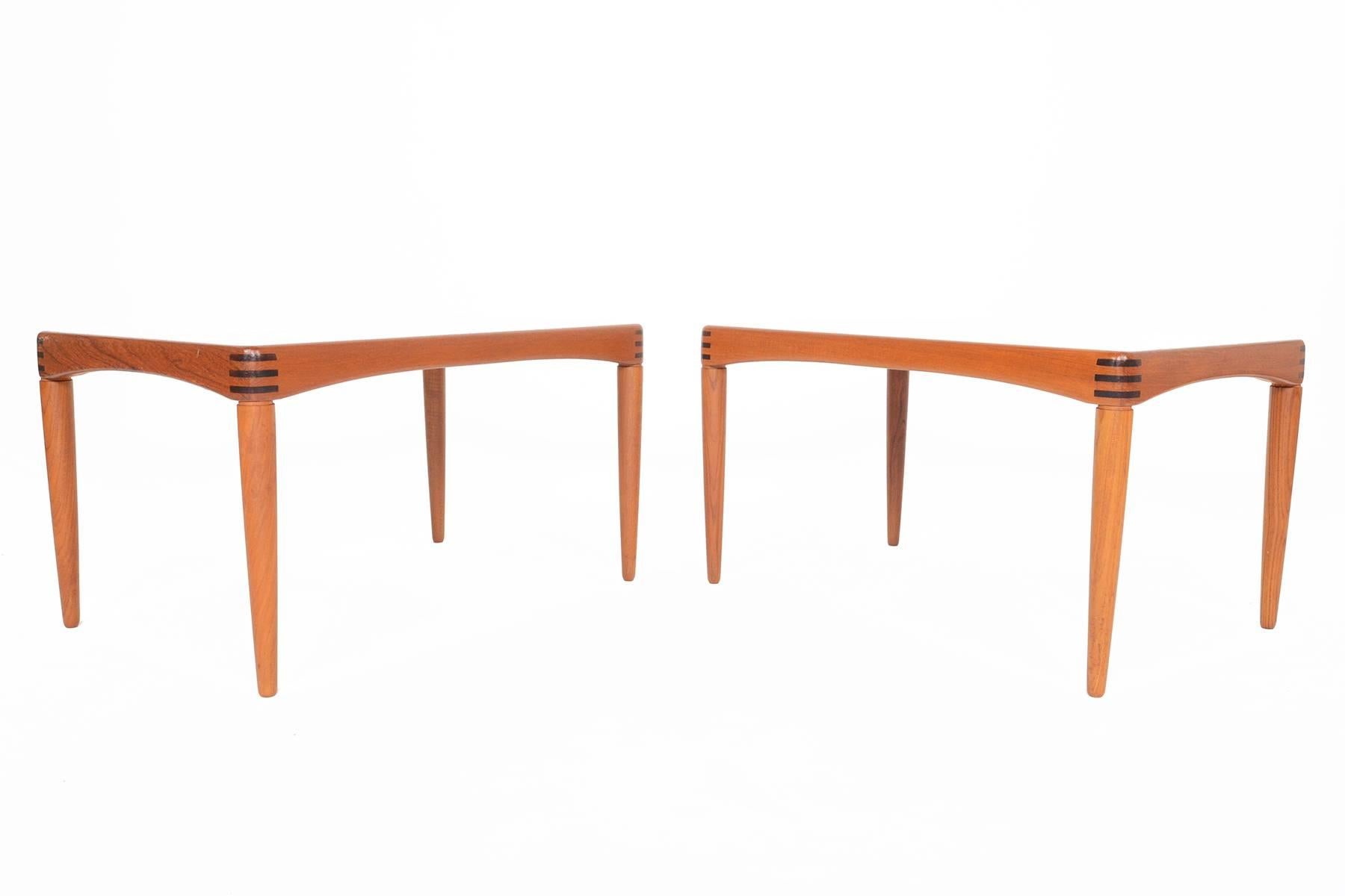 This stunning pair of Danish modern Mid-Century side tables in teak were designed by H.W. Klein for Bramin in the 1960s. Beautiful banding is accented with Brazilian rosewood inlays around the corners. Stands on tapered spindle legs. In excellent
