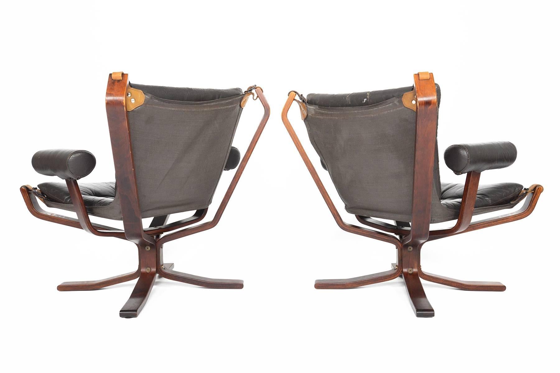 This gorgeous pair of Norwegian modern Falcon chairs was designed by Sigurd Ressell for Vatne Møbler in the early 1970s. Covered in original dark chestnut toned, patinated leather, this ingeniously designed chair is known for its comfort. The