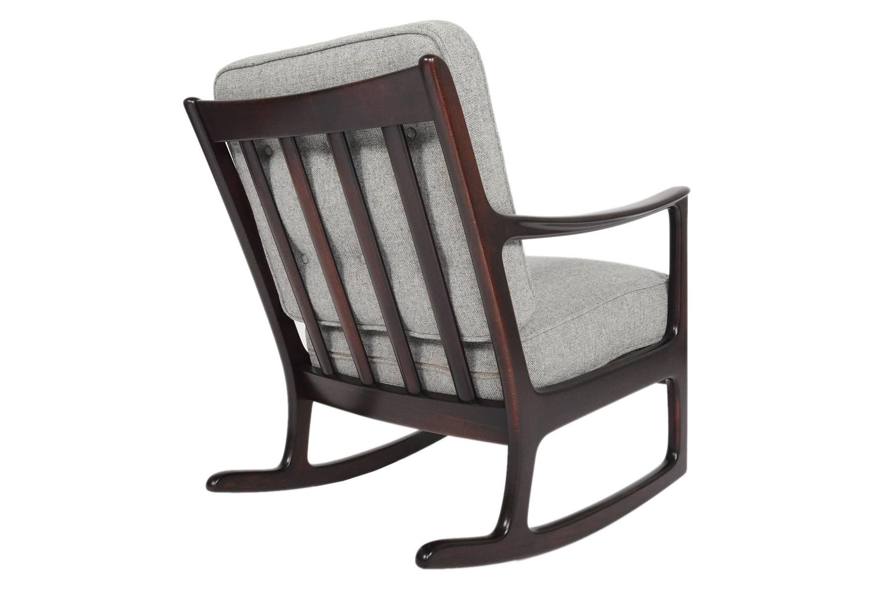 This fantastic Danish Modern Mid-Century rocking chair was designed by Ole Wanscher for France and Daverkosen in the 1960s. Crafted in ebonized beech, this piece is defined by its understated elegant lines and sturdy construction. Recently recovered