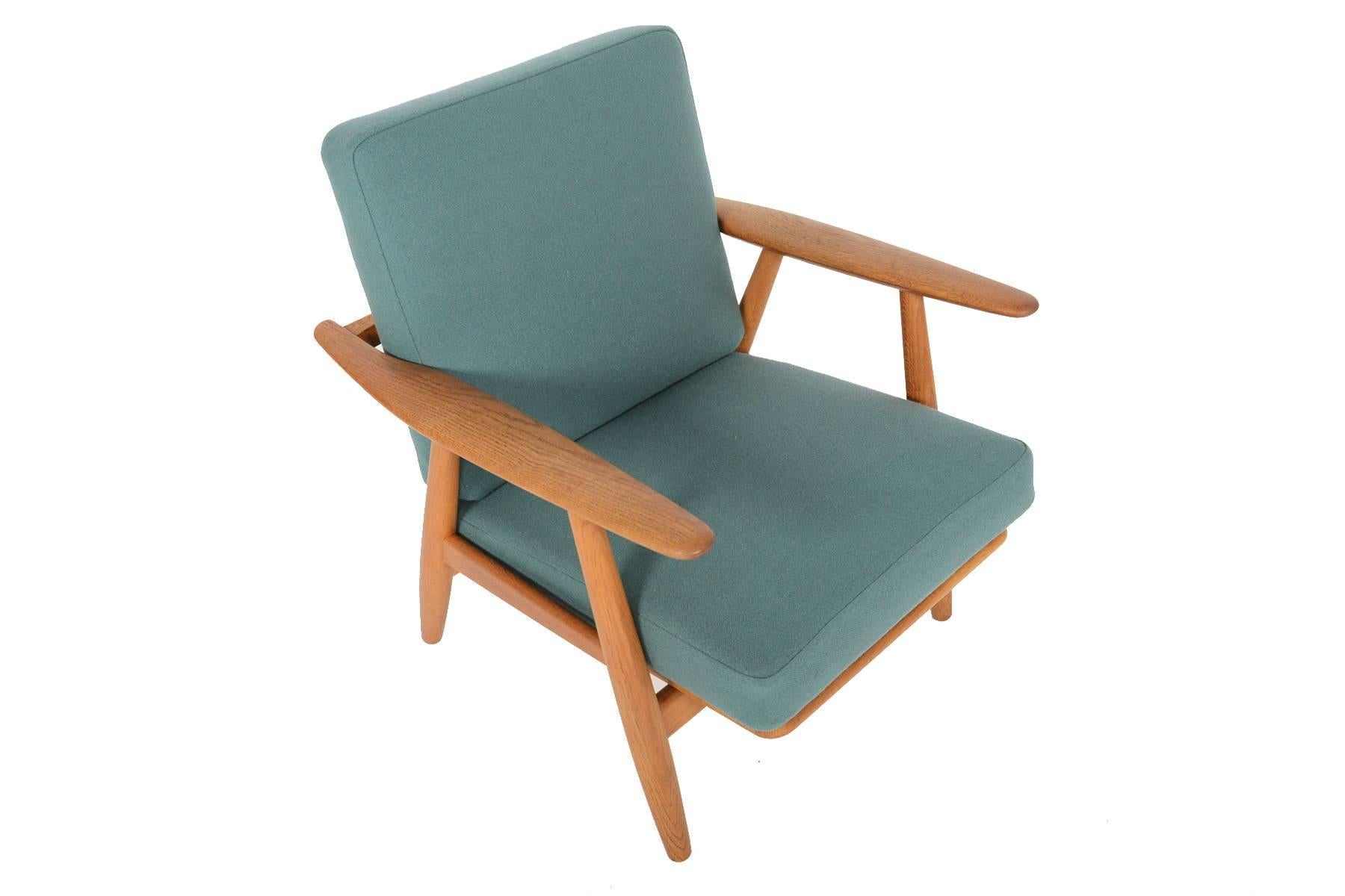 This Danish modern lounge chair model GE-240 was designed by Hans Wegner for GETAMA in 1955. Crafted in quarter- sawn oak, the ergonomic design of this chair is unparalleled. Sculpted 