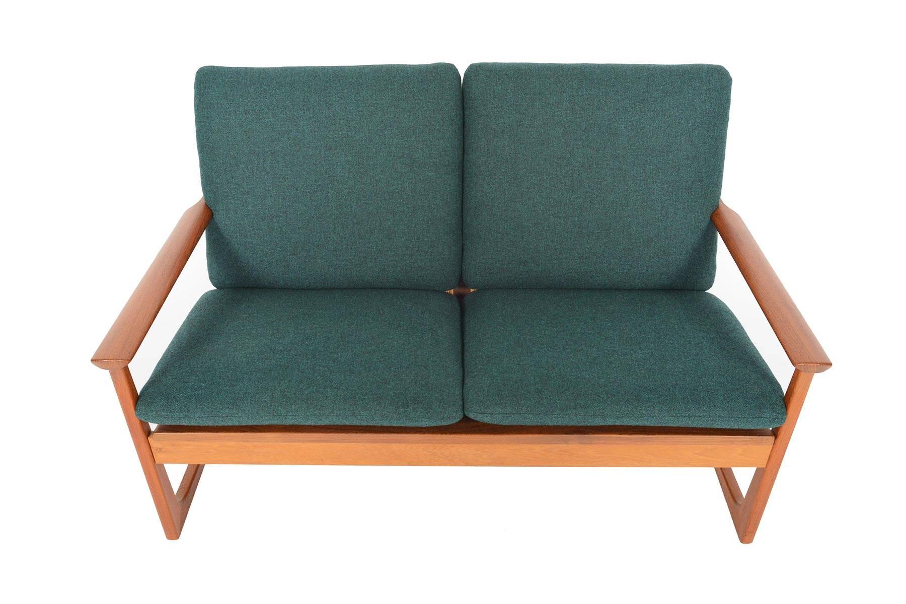 This astounding Danish modern loveseat by Hans Olsen will instantly elevate the design of any room! The hand- woven cane back offers a beautiful detail. The sculpted teak arms cap the sleigh base for a fascinating Silhouette from side views. A true