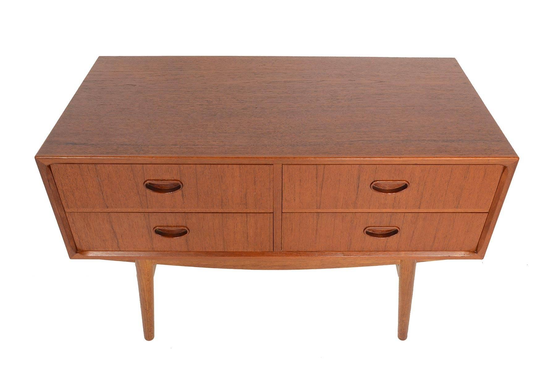 This wonderful Danish modern midcentury four-drawer gentleman's chest is cased in teak but stands on contrasting oak base. Excellent for use as larger nightstand, small dresser, or entry chest, this well crafted piece features four drawers accented