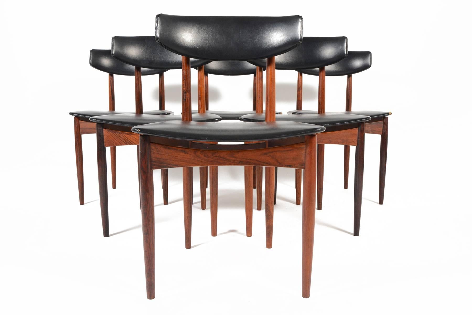 This gorgeous set of six mid century dining chairs in rosewood is in the manner of Ib Kofod-Larsen. Perfect for pairing with any vintage or modern table, generously padded backrests and seats provided hours of comfortable dinning. Turned rosewood