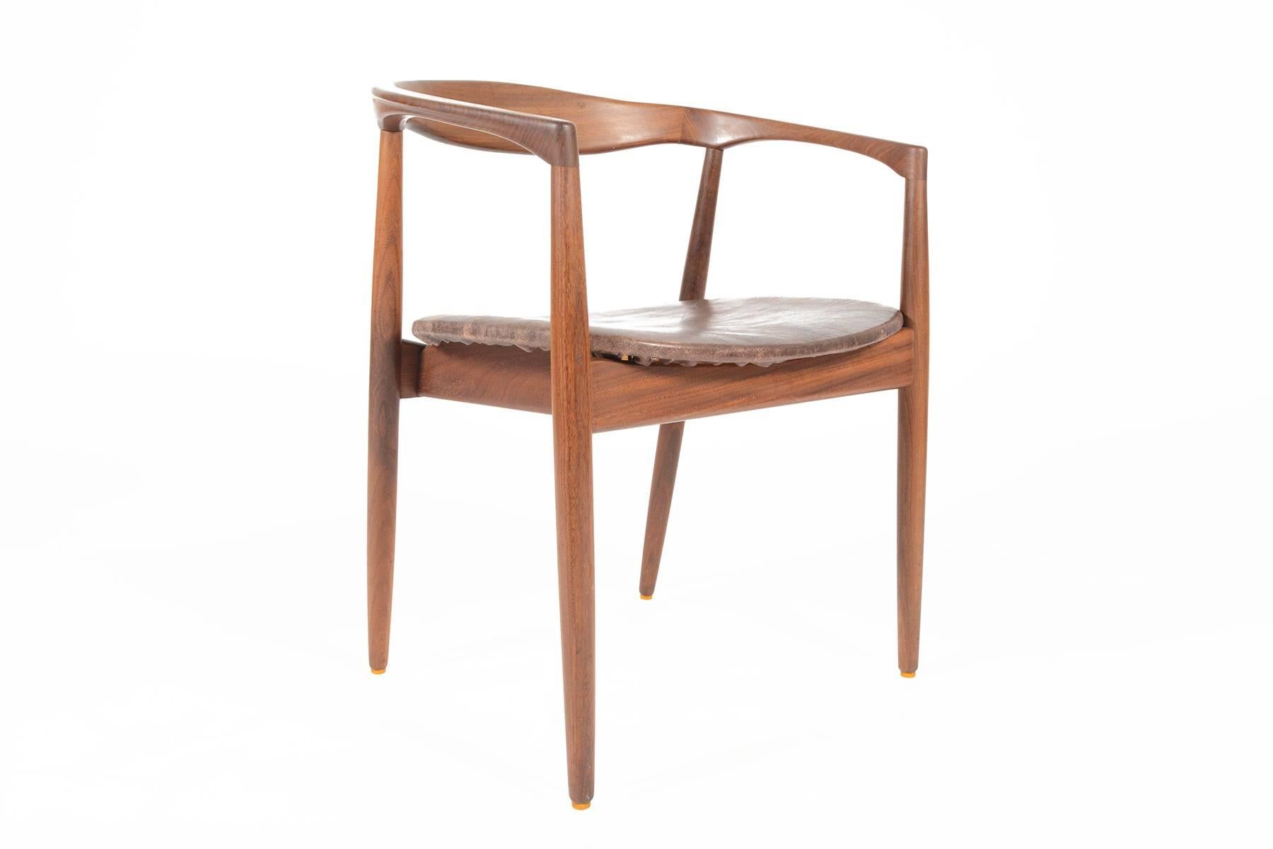 This Danish modern mid century side chair was designed by Kai Kristiansen for Magnus Olesen in 1959. The curved solid teak back extends into armrests for a comfortable and ergonomic feel. Excellent craftsmanship throughout. The seat bottom wears its