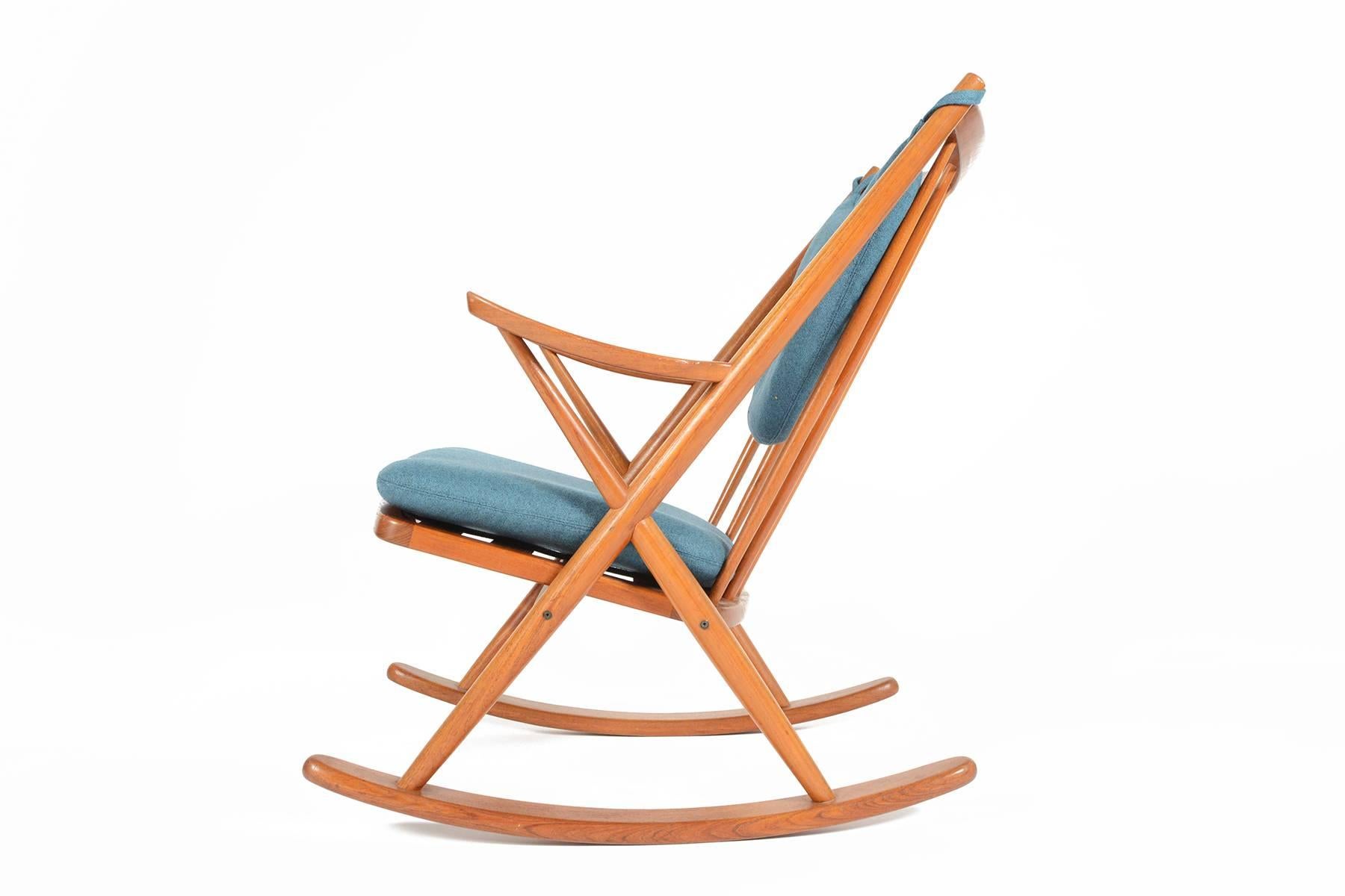 This Danish modern mid century rocking chair is a rare find. Crafted in teak and designed by Frank Reenskaug for Bramin, this rocker has been recently recovered in Danish Kvadrat cerulean wool. The frame is in excellent vintage condition with