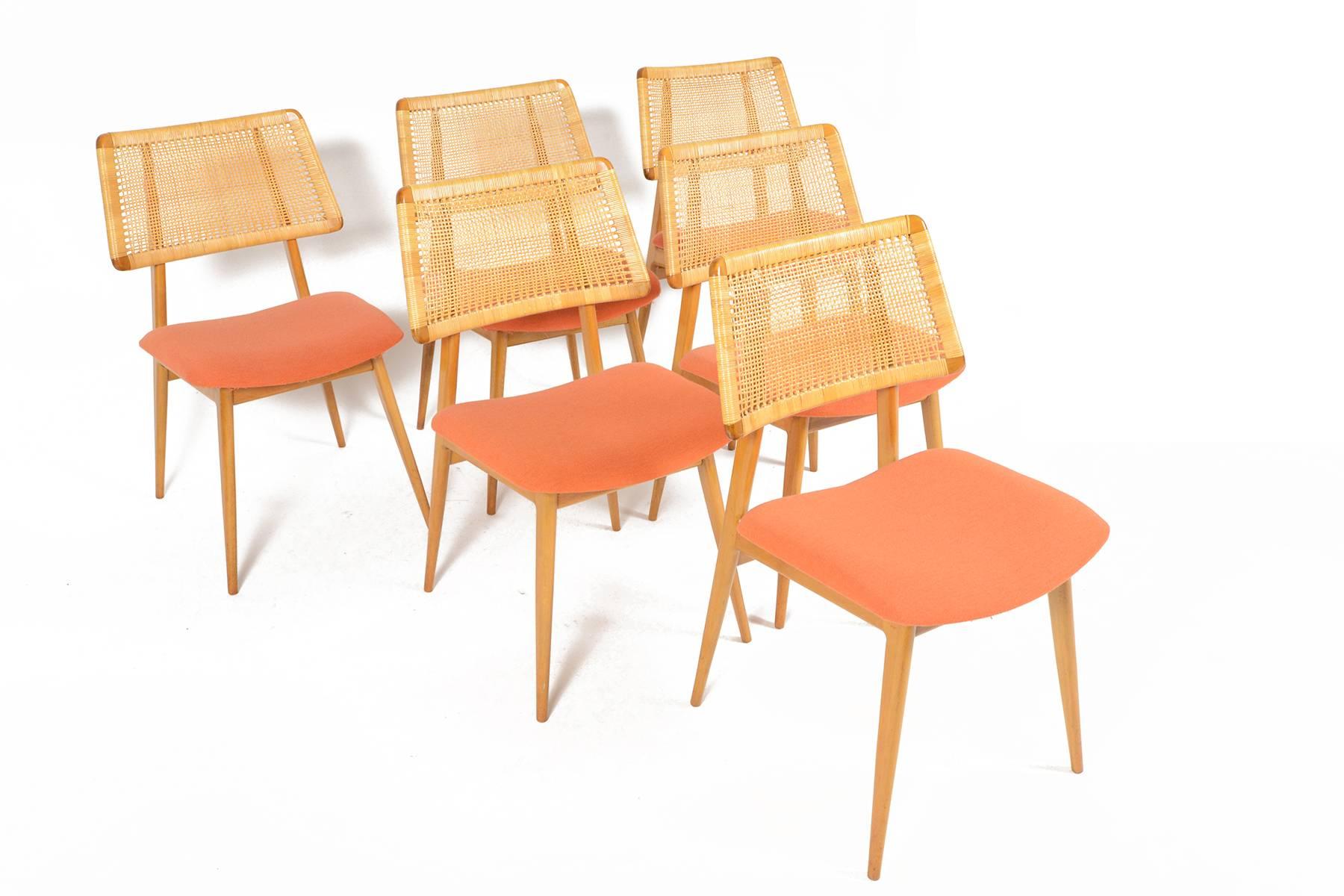 This set of six mid century beech dining chairs was designed and manufactured by Habeo of Germany in the 1960s. This stunning modern design features original rattan backrests. Seat bottoms wear their original coral wool upholstery. Frames are in