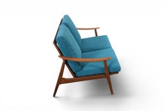 Canapé deux places vintage des années 1960, avec structure en teck et coussins aux teintes chatoyantes