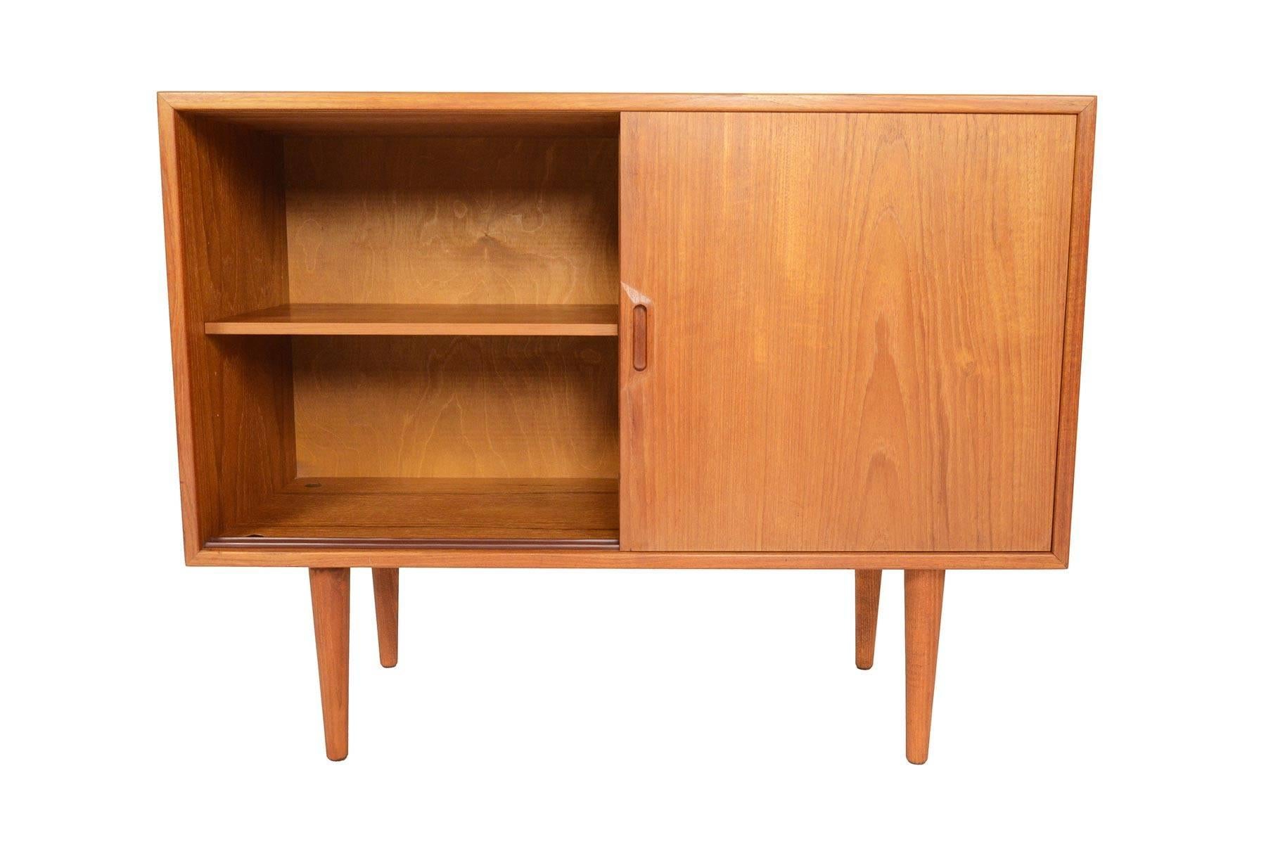 This gorgeous two-door credenza in teak was designed by Sven Ellekaer for Albert Hansen in the 1960s. Two sliding doors open to reveal a split interior cabinet with adjustable teak shelving for plenty of storage. In excellent original condition.