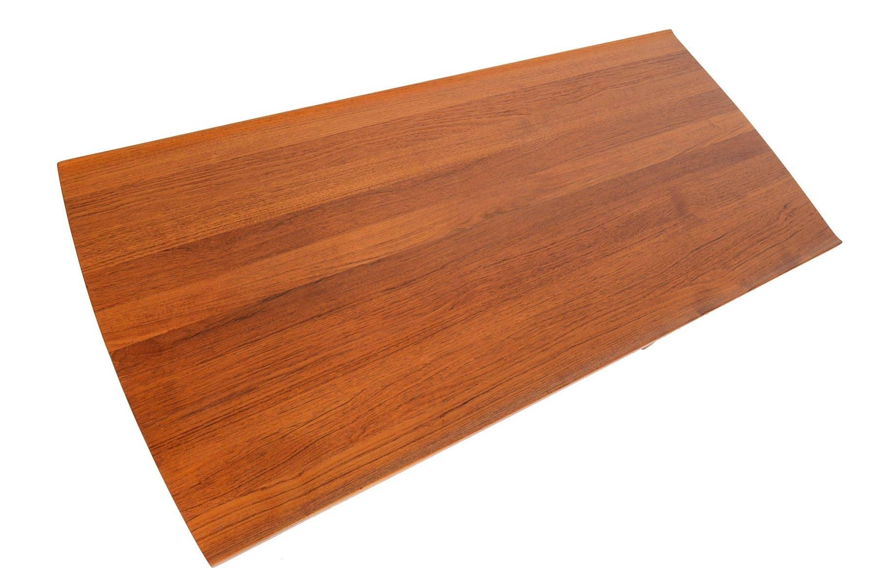 This Swedish modern midcentury coffee table is a wonderful example of high end Scandinavian craftsmanship of the 1960s. Designed by Tove & Edvard Kindt-Larsen for AB Seffle Møbelfabrik, this table is crafted in solid teak and accented with exposed