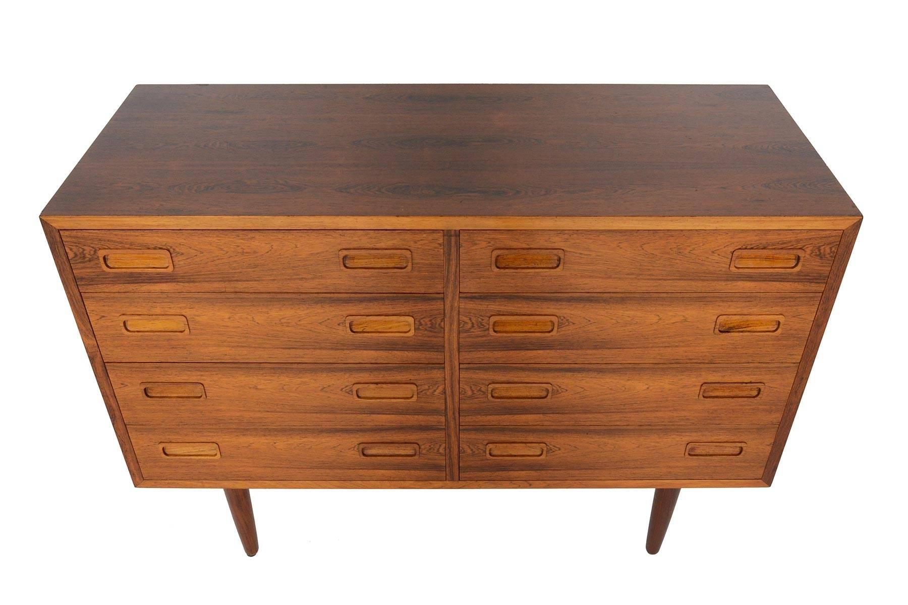 Danish modern midcentury low eight-drawer double dresser in Brazilian rosewood.  hand-carved rosewood drawer pulls accent the excellent yet understated craftsmanship of this Classic piece.  Manufactured by Hundevad & Co in the 1960s. In excellent