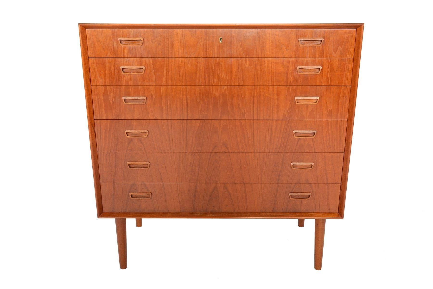 This gorgeous Danish modern midcentury highboy dresser features six extra wide drawers accented by hand carved rectangular drawer pulls. Designed by Borge Seindal, this stunning piece was manufactured on is finished in brilliant old growth teak.