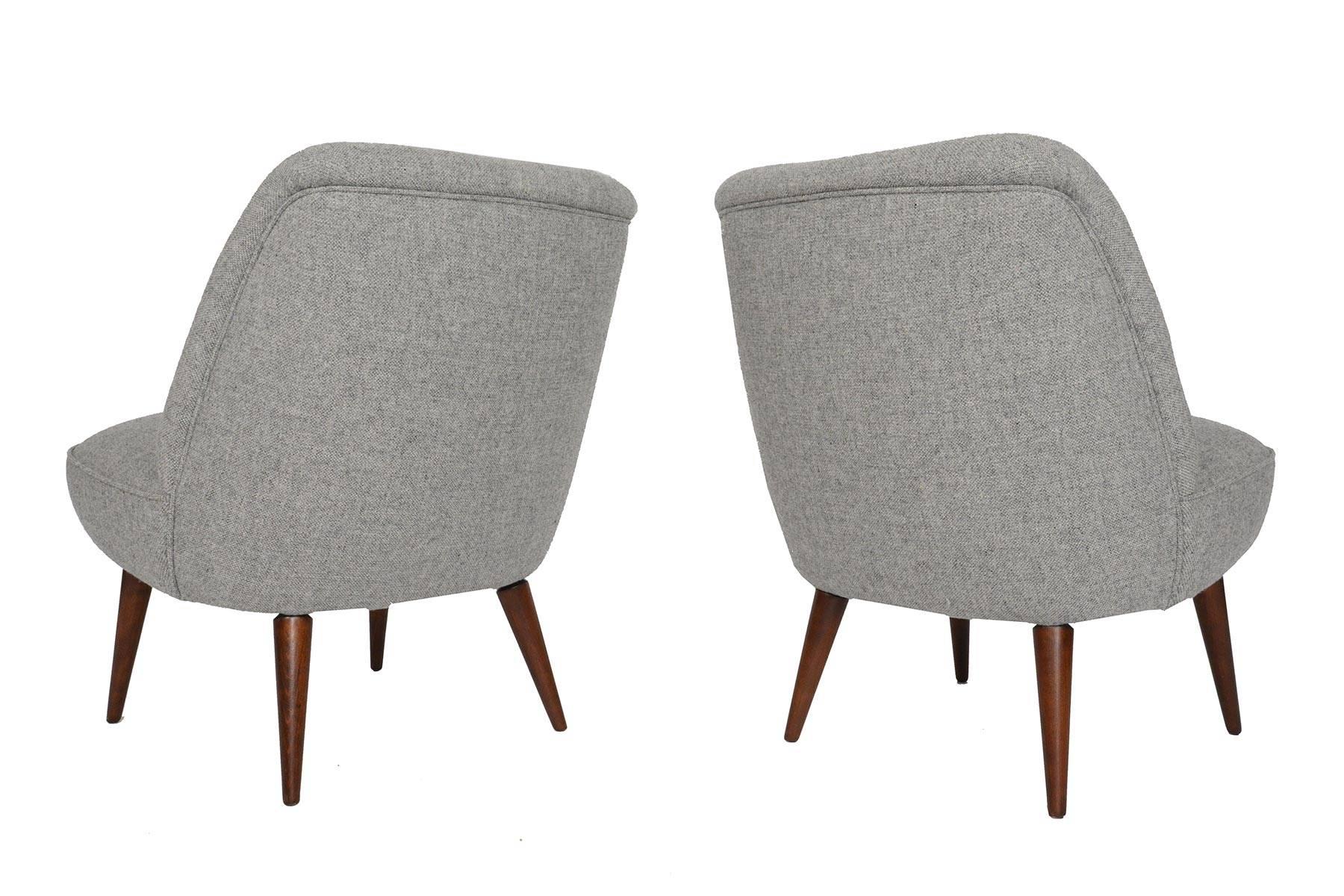 This lovely pair of German midcentury slipper lounge chairs will add elegance and style to any modern home. Legs have been recently refinished in period correct toned lacquer. Chairs have been newly recovered in grey Hallingdal wool by Maharam. In