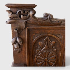 Un banc médiéval ancien, sculpté, avec espace de rangement