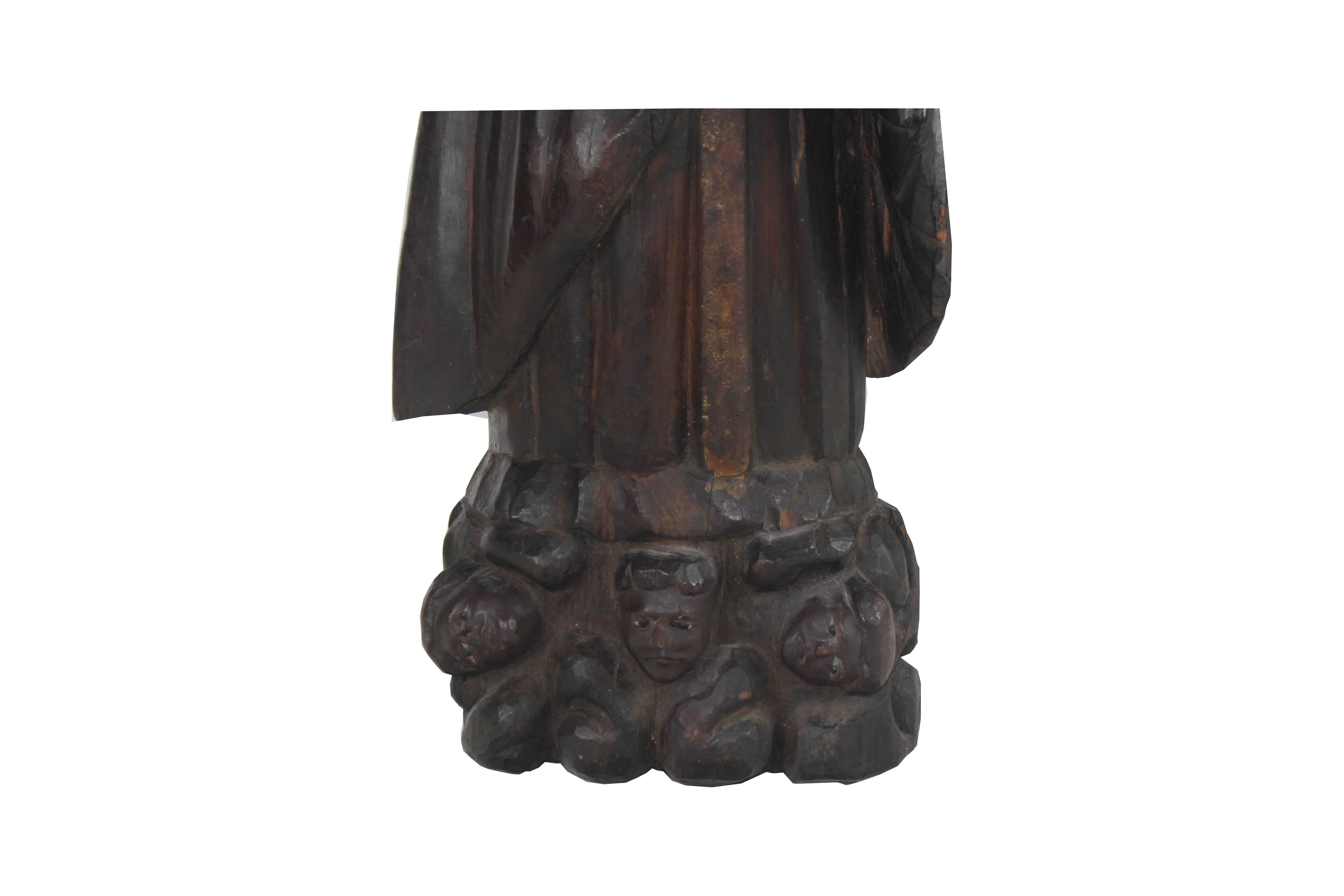 19th-century wood carved glass eyes Santos standing on a plinth with cherub heads.