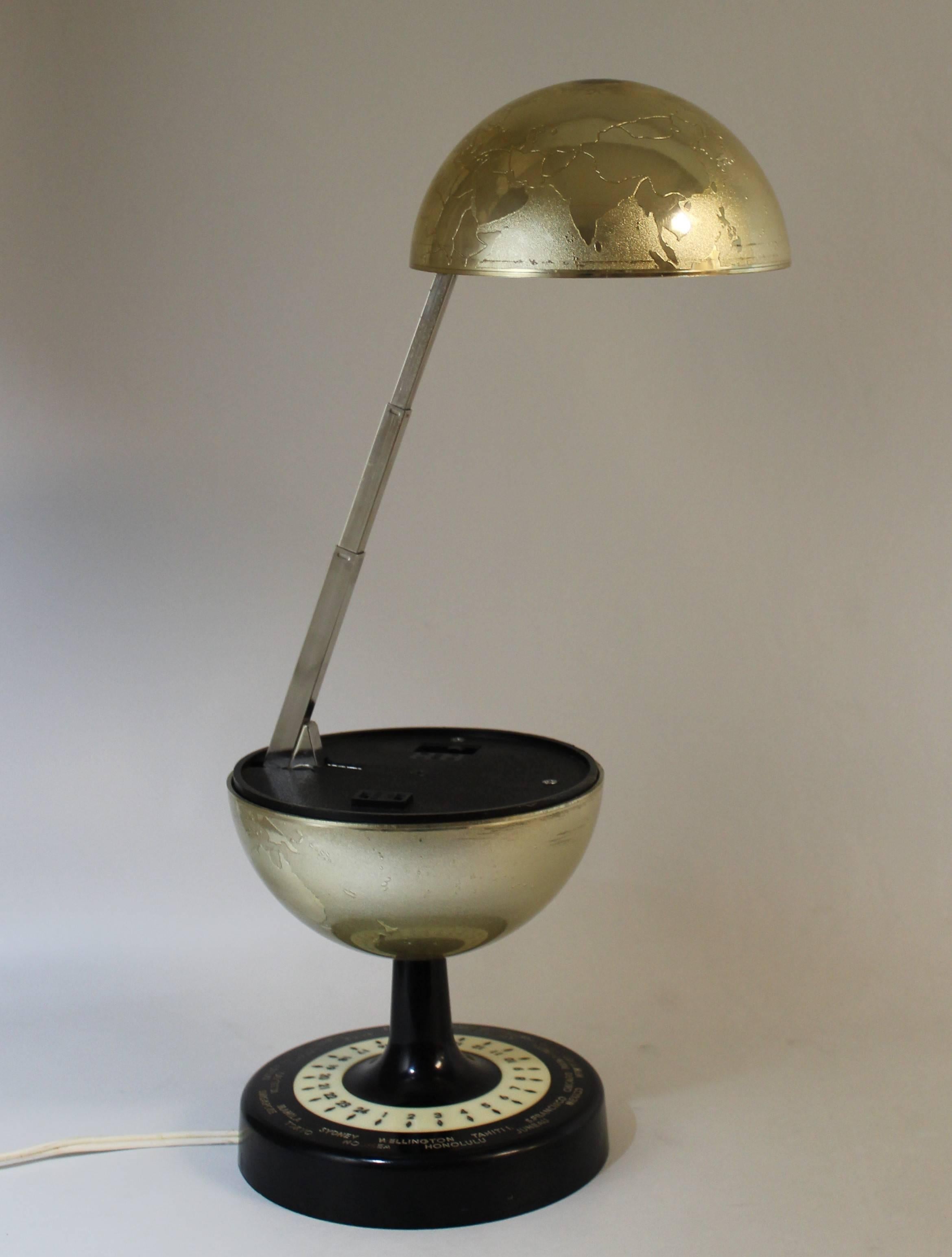 Mid-Century Modern articulating world globe lamp.
Made by Universal Lamp Co., Japan. The base rotates and shows the time differentials from cities across the world. The lamp extends to over 14 inches and the head adjusts to multiple positions.