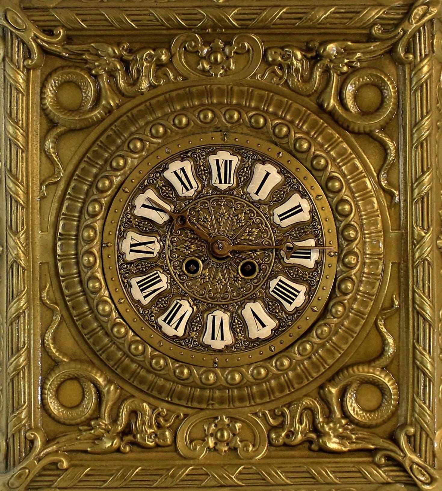 Highly decorative clock which features porcelain numerals, mythical winged serpents, acanthus leaves and a bearded Jester head which sits atop the clock.