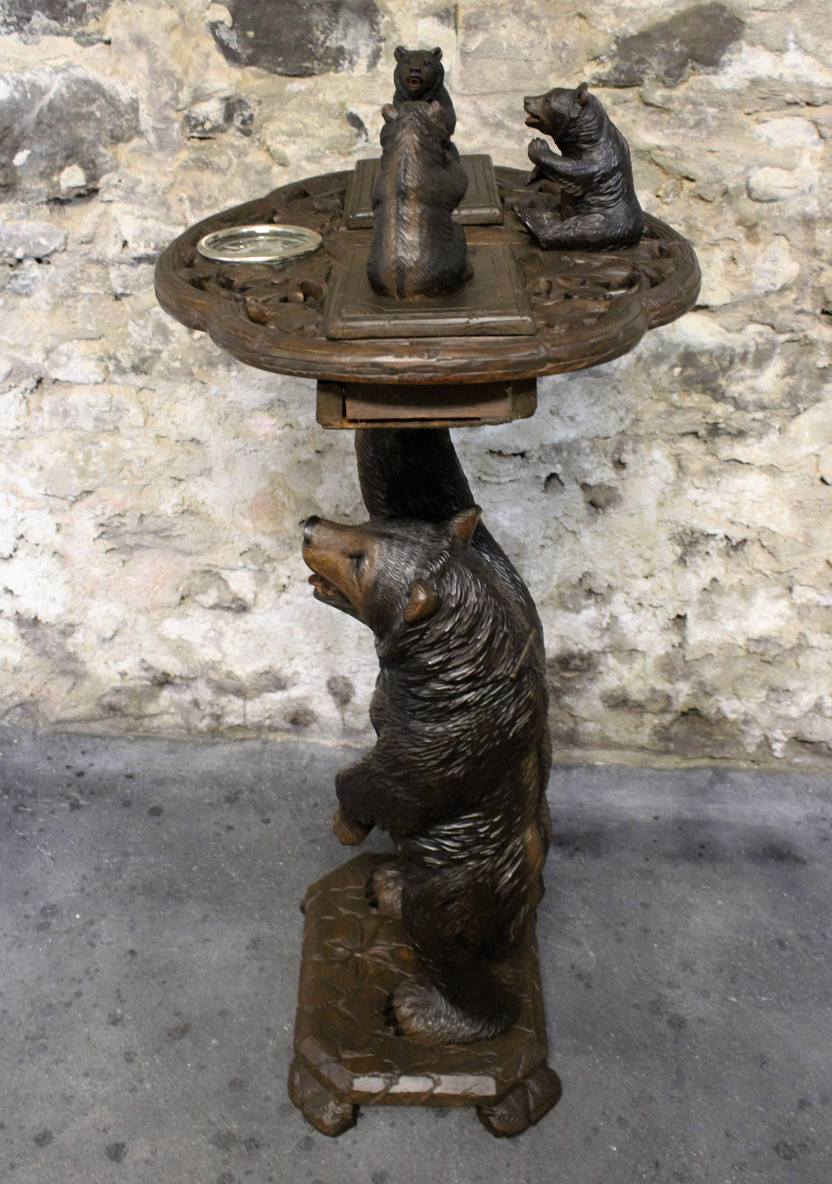 Very stylish Black Forest smokers stand, circa 1890. The stand is topped with three realistically carved bears. The two bears at the front are hinged and open to reveal small compartments, and beneath the left one is a box with a winding musical