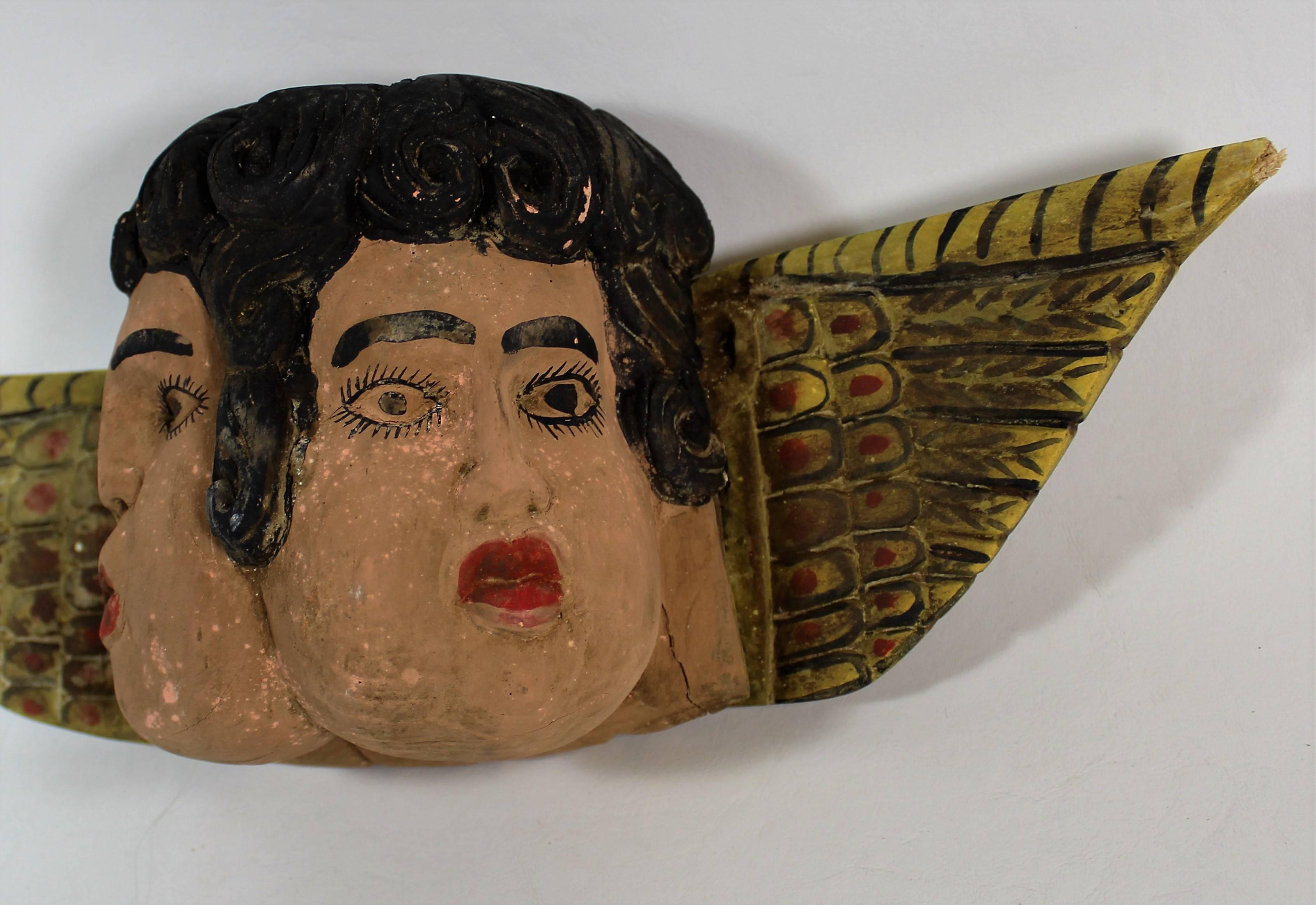 Folk Art hand-carved double faced cherubs.