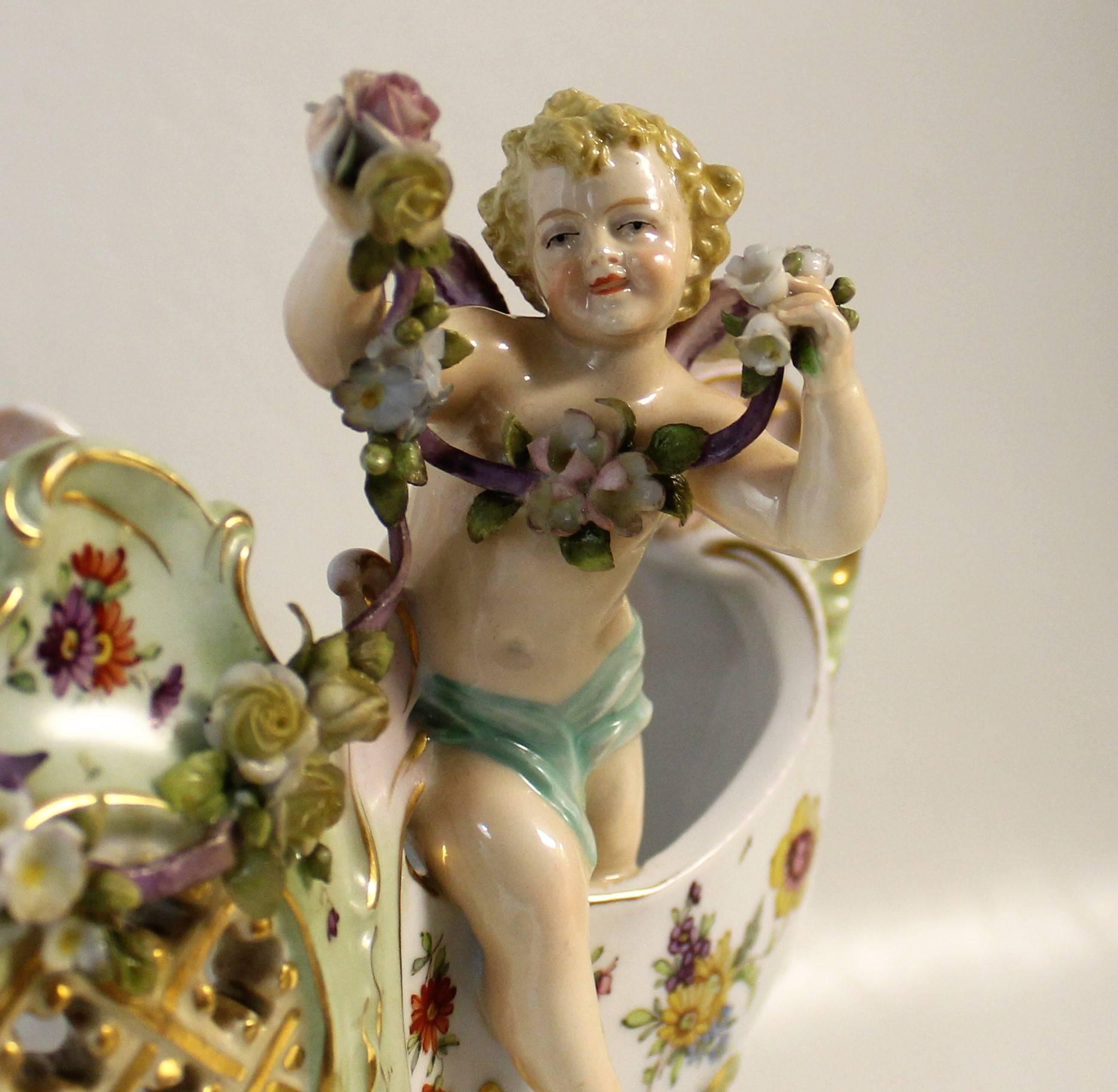E & A Muller 'Corona' porcelain figural cherub Jardinière or centerpiece bowl.

19th century Austrian porcelain centerpiece bowl or jardiniere beautifully enamelled in rich colors with floral sprays and gilt highlights. This stunning Rococo piece