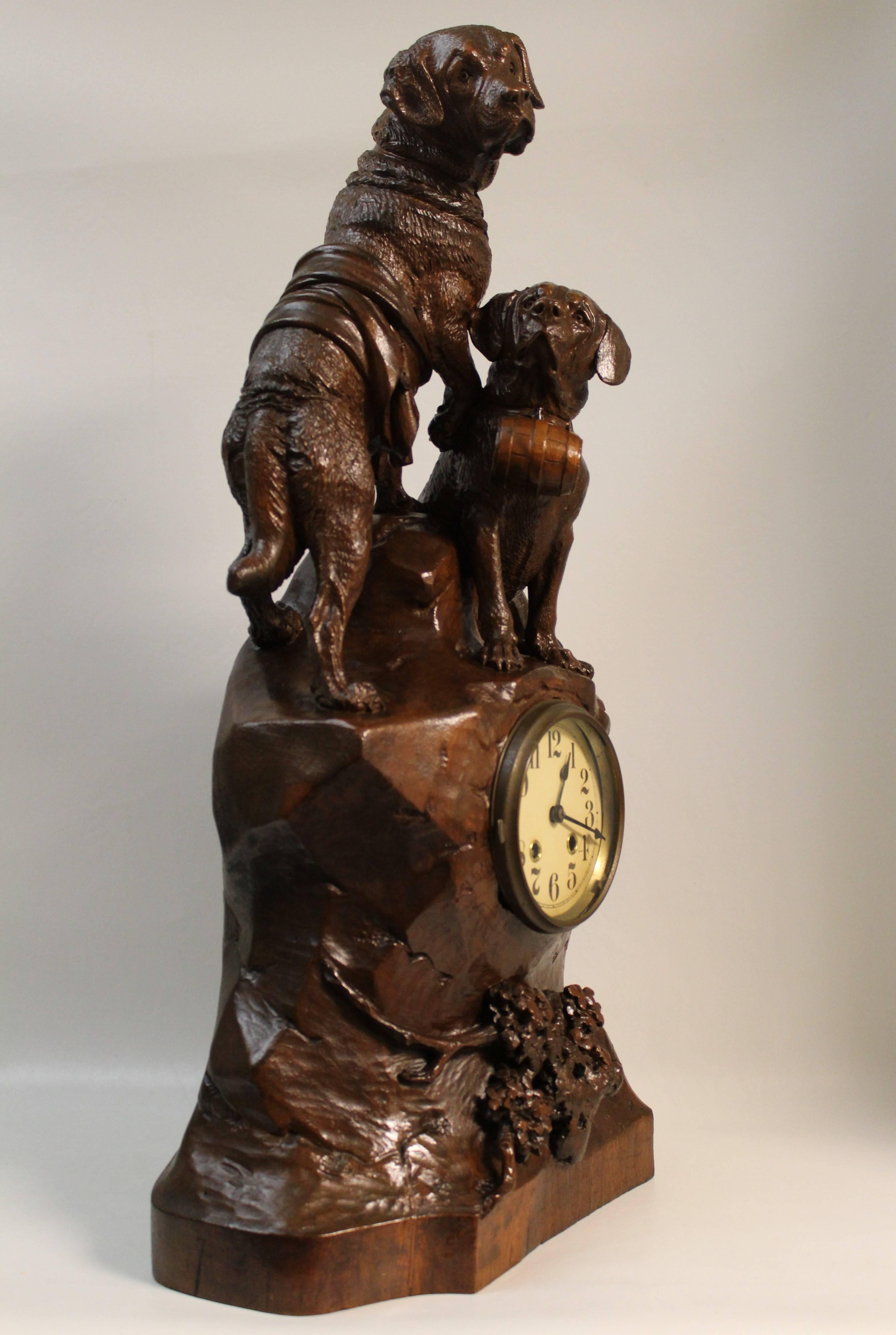 An excellent quality 19th century Swiss Black Forest carved mantel clock hand-carved of Linden wood. Very well executed with traditional theme of life saving St. Bernard dogs carrying whisky barrels above carved rocks and plants. The clock is fully