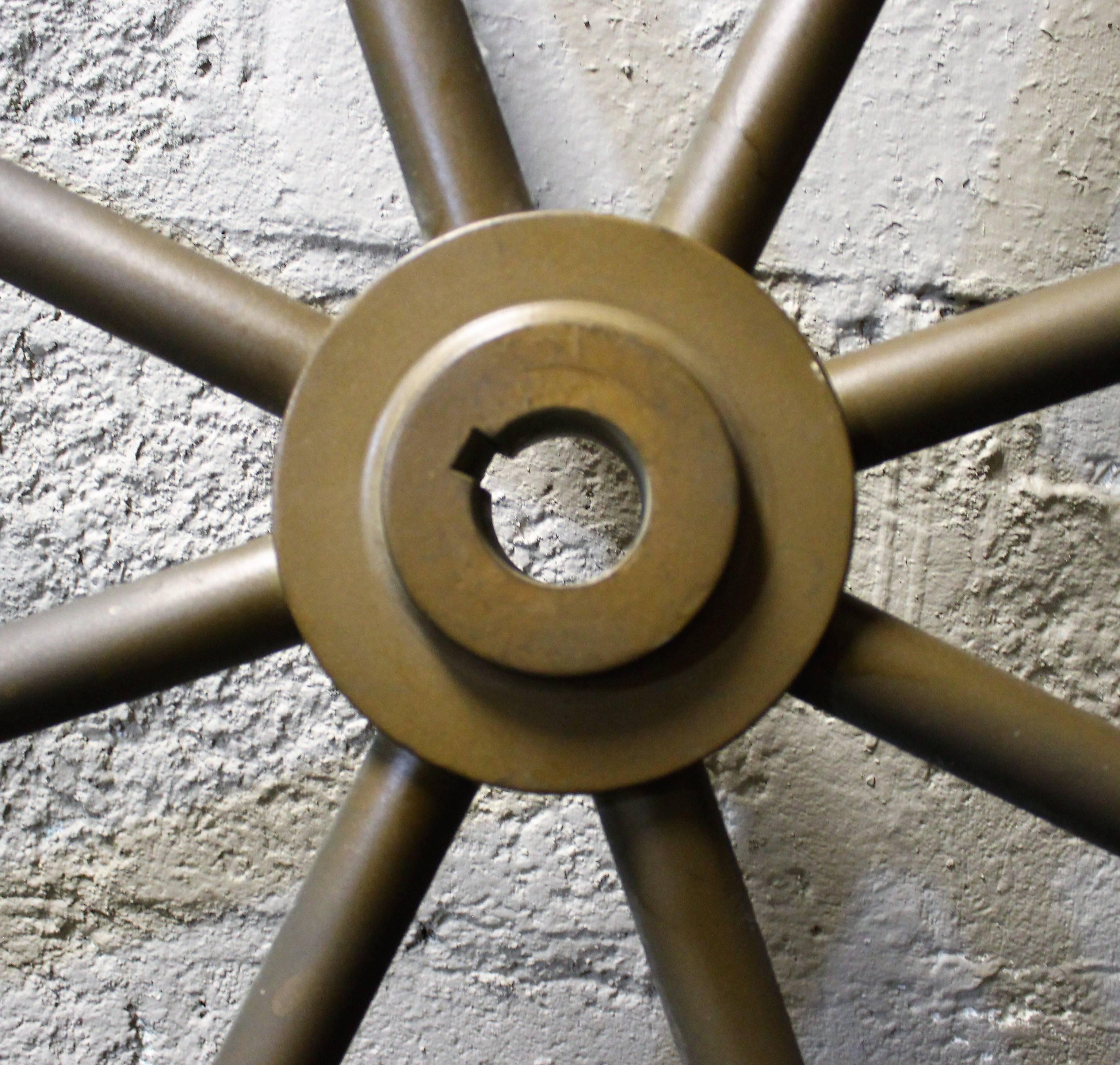 Heavy and large solid brass ship's wheel with beautiful aged patina.