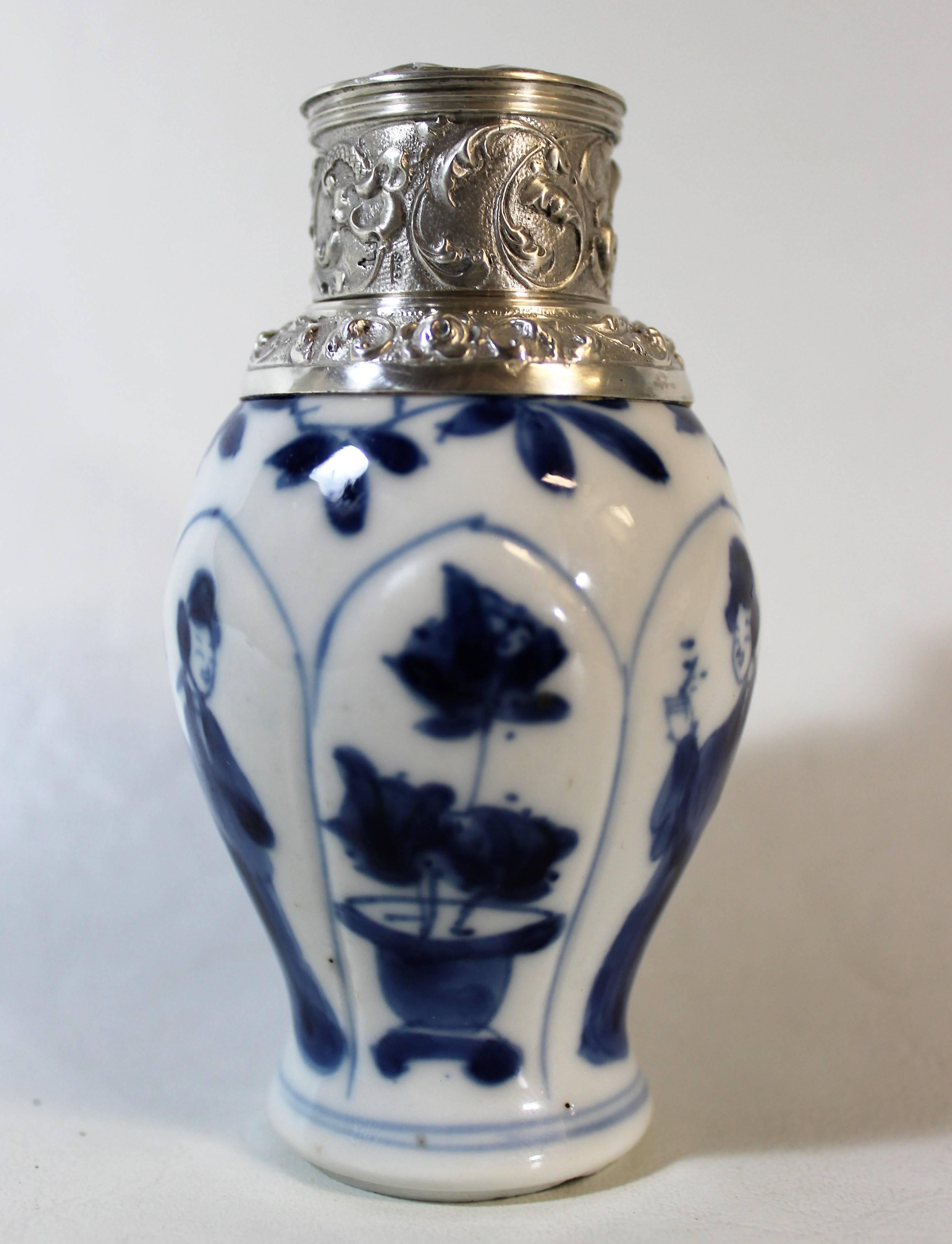 19th century Chinese porcelain tea caddy with Dutch hallmarked sterling silver lid featuring scrolling foliate and floral designs and a windmill done in relief.