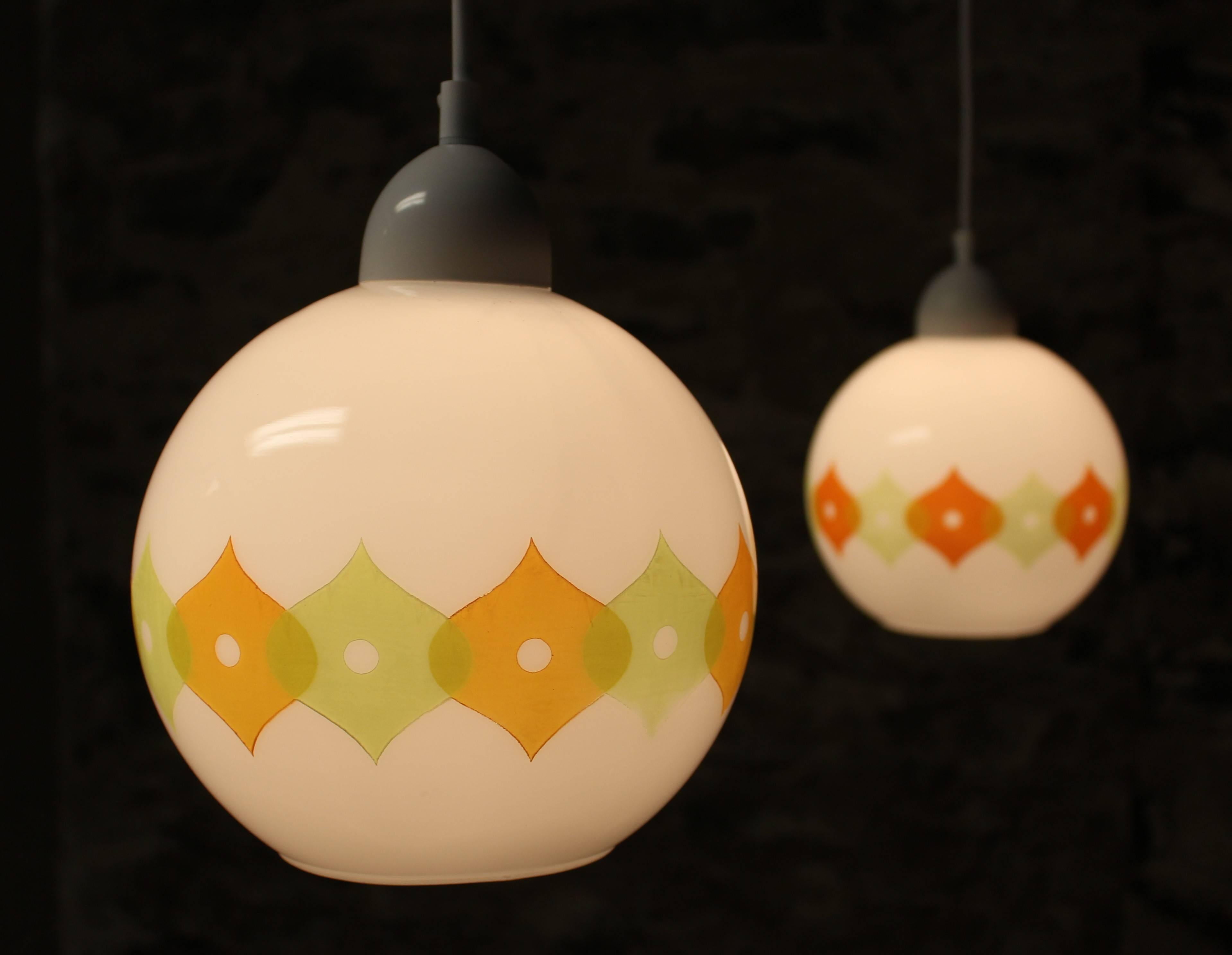 Beautiful handblown French Mid-Century Modern pendant lights. Made by Cvv Vianne Co in France. They feature a hand-painted abstract scrolling design on eggshell white bases. All six lights have a moss green color throughout while three feature more