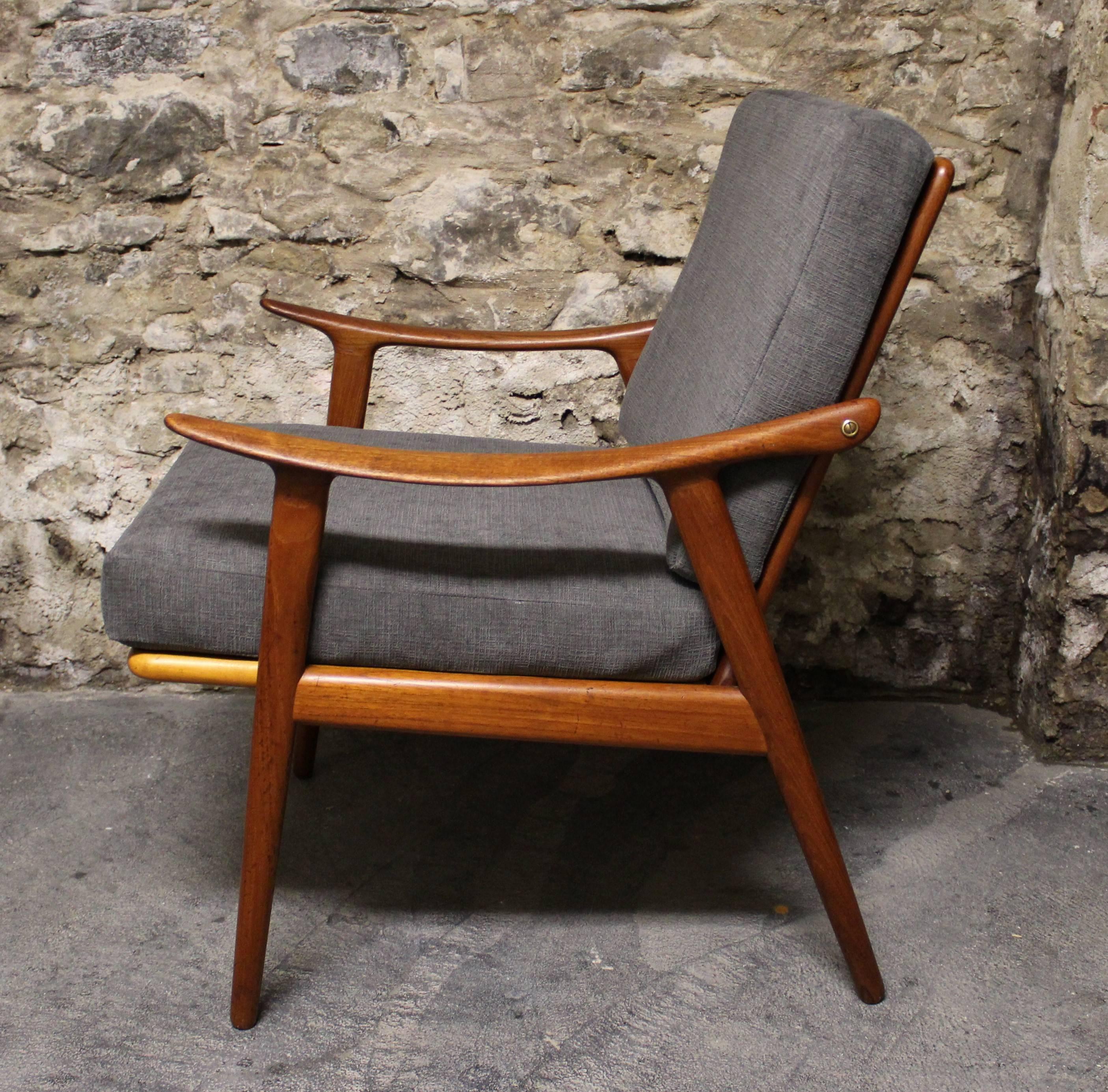 This easy chair was designed by Fredrik A. Kayser in the 1950s and manufactured by Vatne Lenestolfabrikk in Norway. The frame is made from solid teak and features organically formed armrests. It has been re-upholstered in a slate grey fabric. The