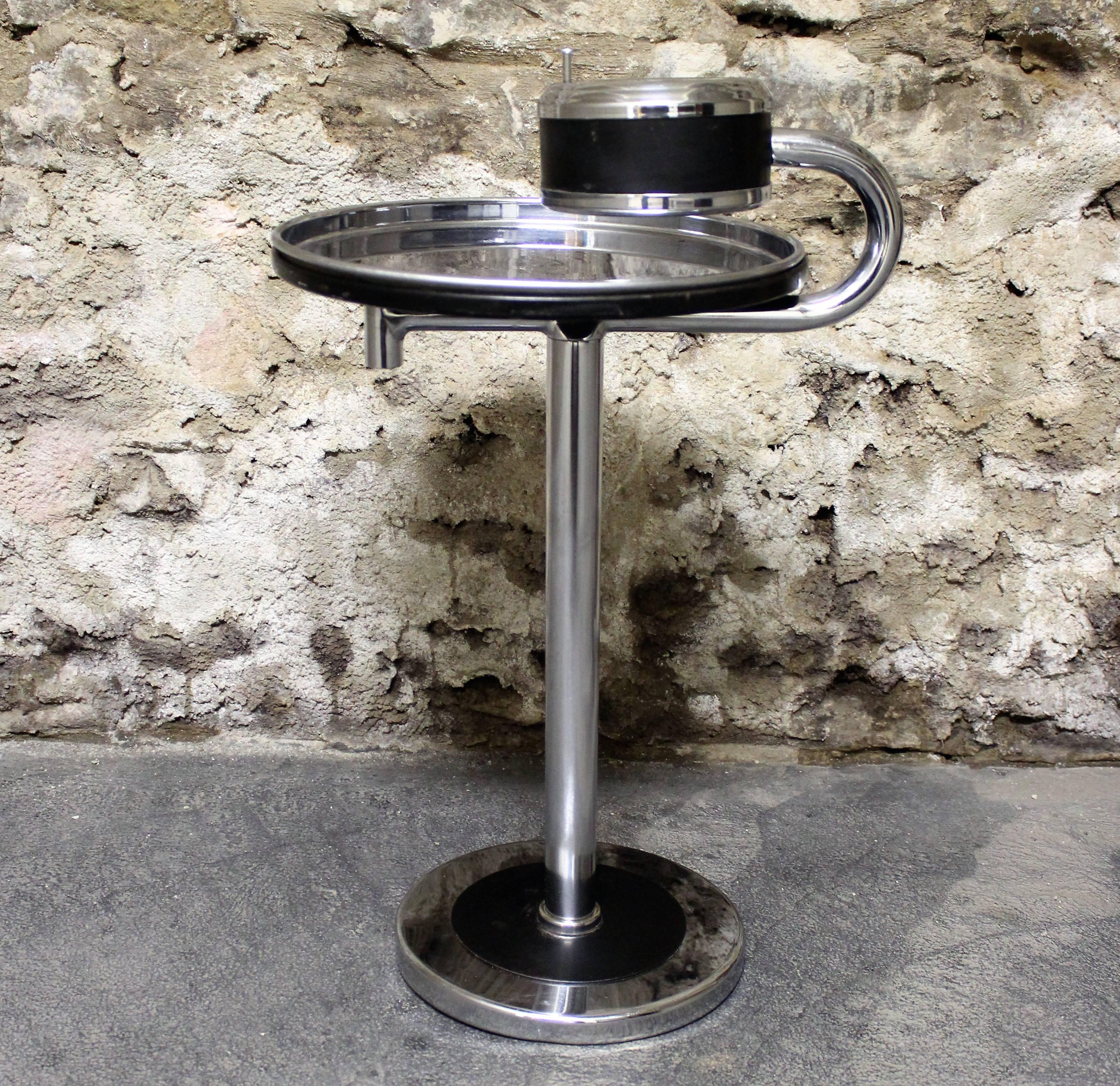Fantastic chrome smoking stand made for Howell by designer Wolfgang Hoffman. Classic American Art Deco design. It features a great swing arm table for your cocktails, cigarettes, accessories or whatever your pleasure. The ashtray has a push button