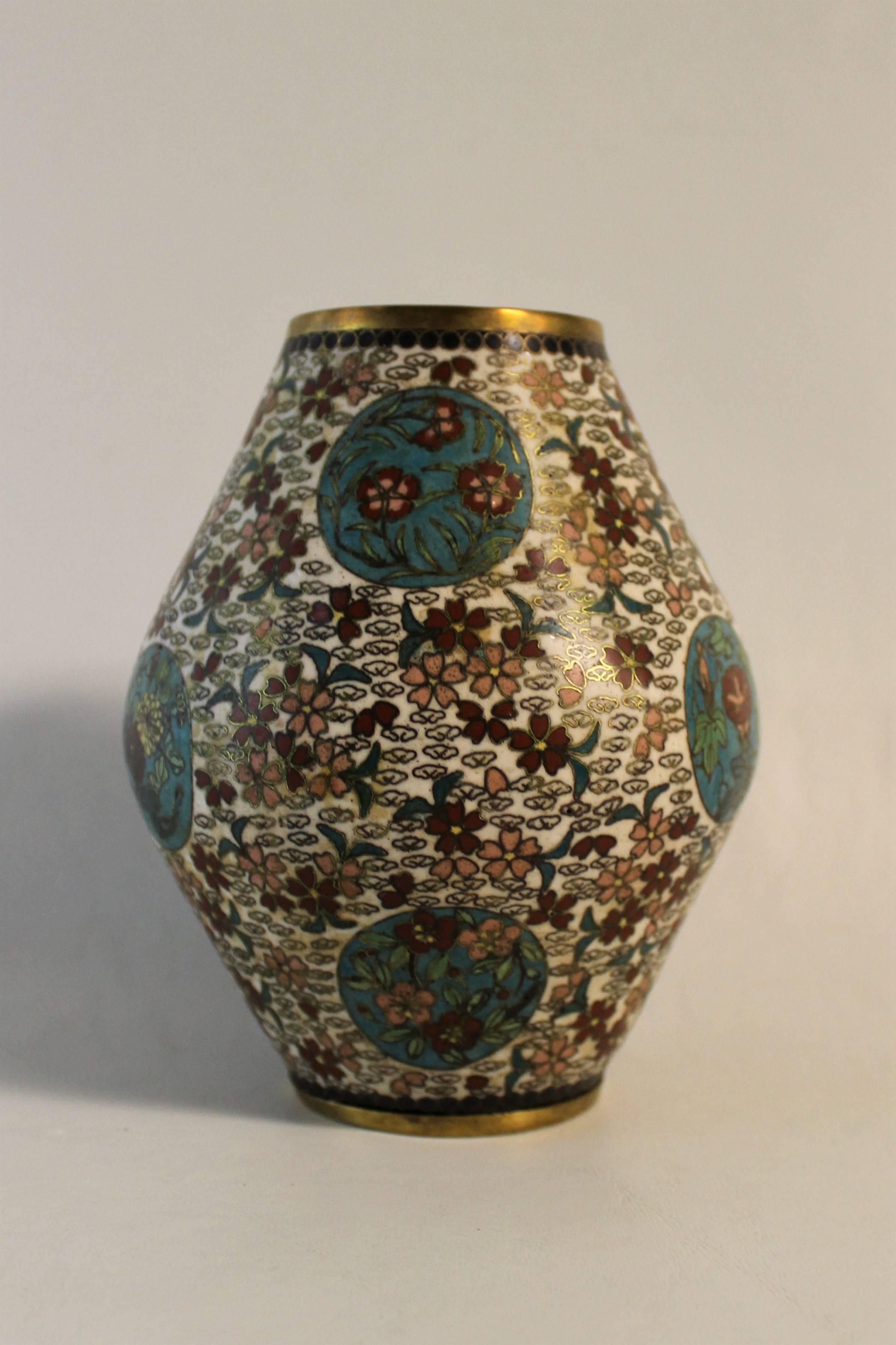 Japanese cloisonne vase dating to the Meiji period. It is beautifully decorated with turquoise roundels filled with flowers on a white ground accented with a floral design.