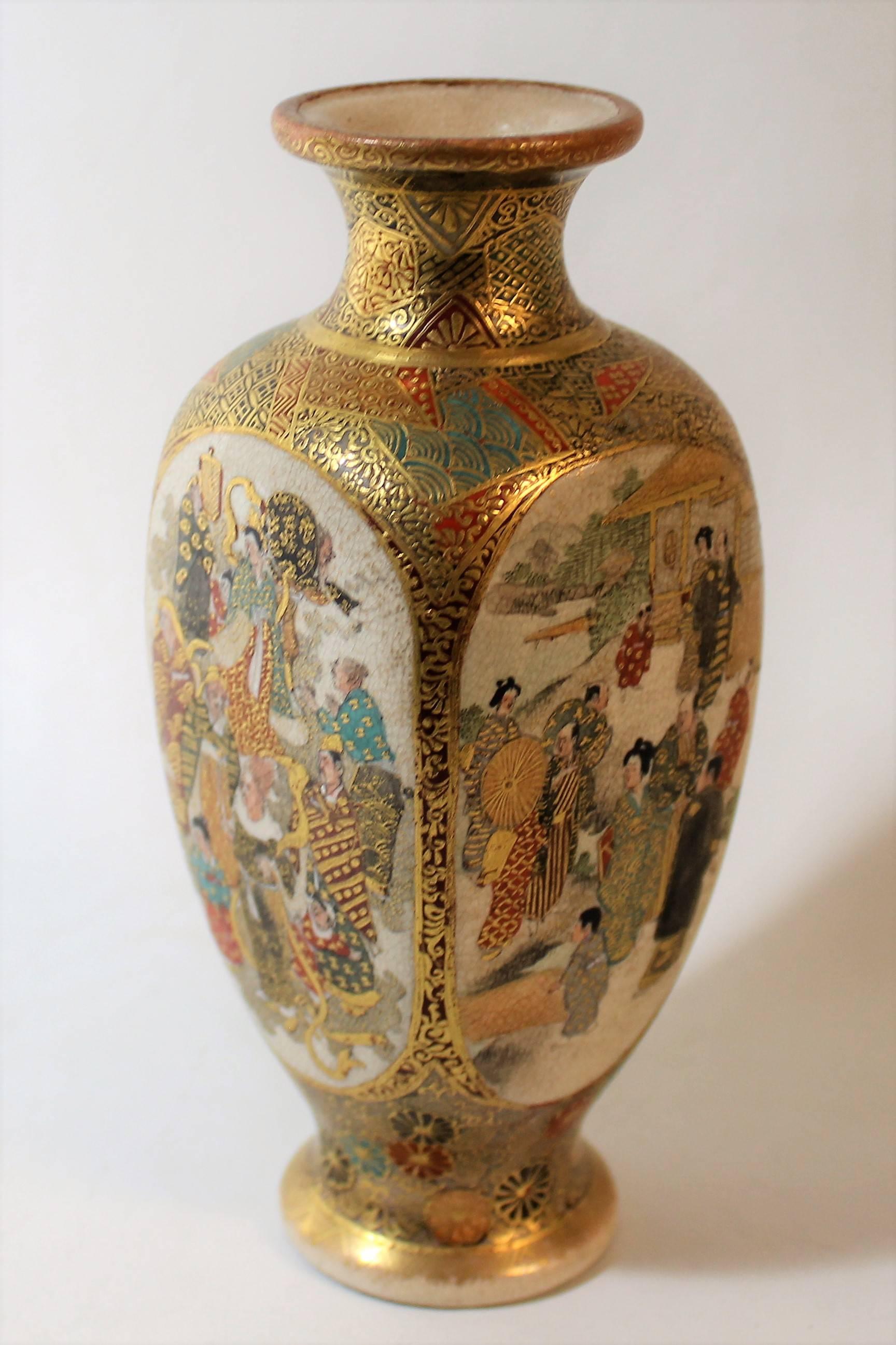 Japanese Satsuma pottery vase dating to the late 19th century. The vase is made in four sided form and heavily accented with gilt throughout. Each side of the vase is hand-painted with figural scenes in various activities.